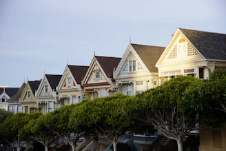 Colorful victorian houses line a street.