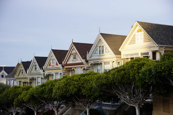 Colorful victorian houses line a street.