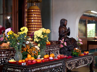 An ornate altar is set with flowers and fruit.
