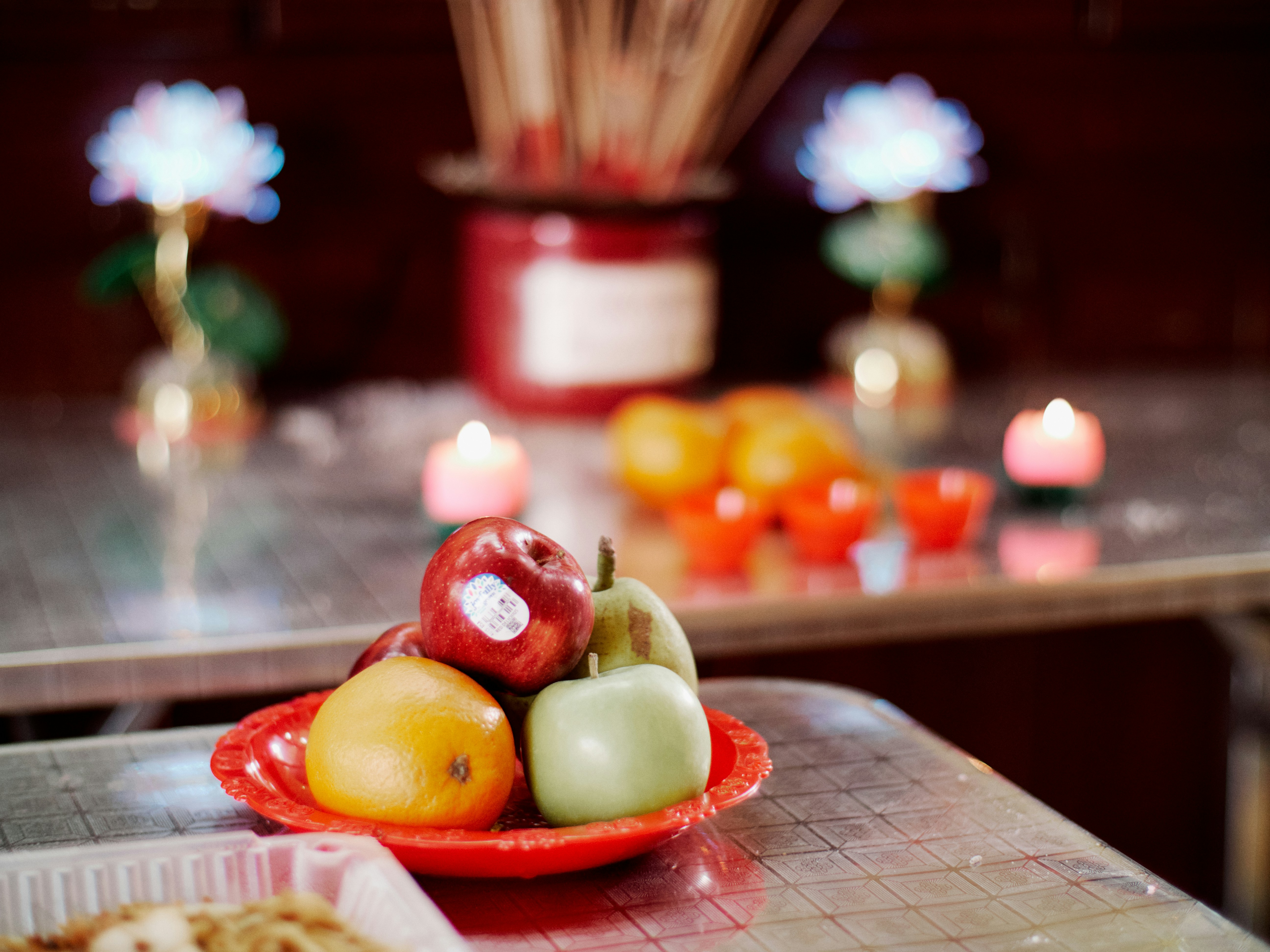 Fruits, candles, and incense create a spiritual offering.