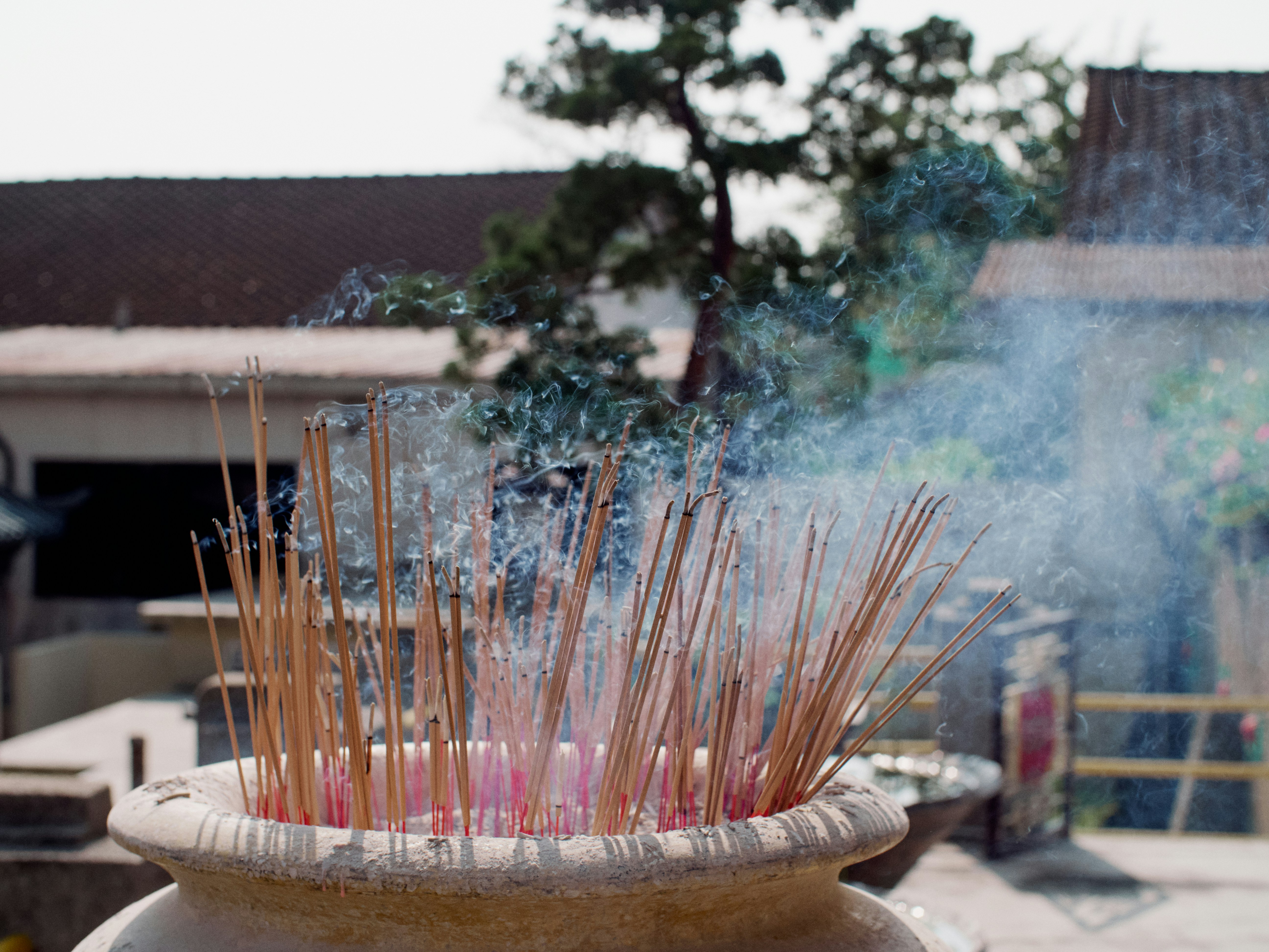 Incense sticks burn and release fragrant smoke.