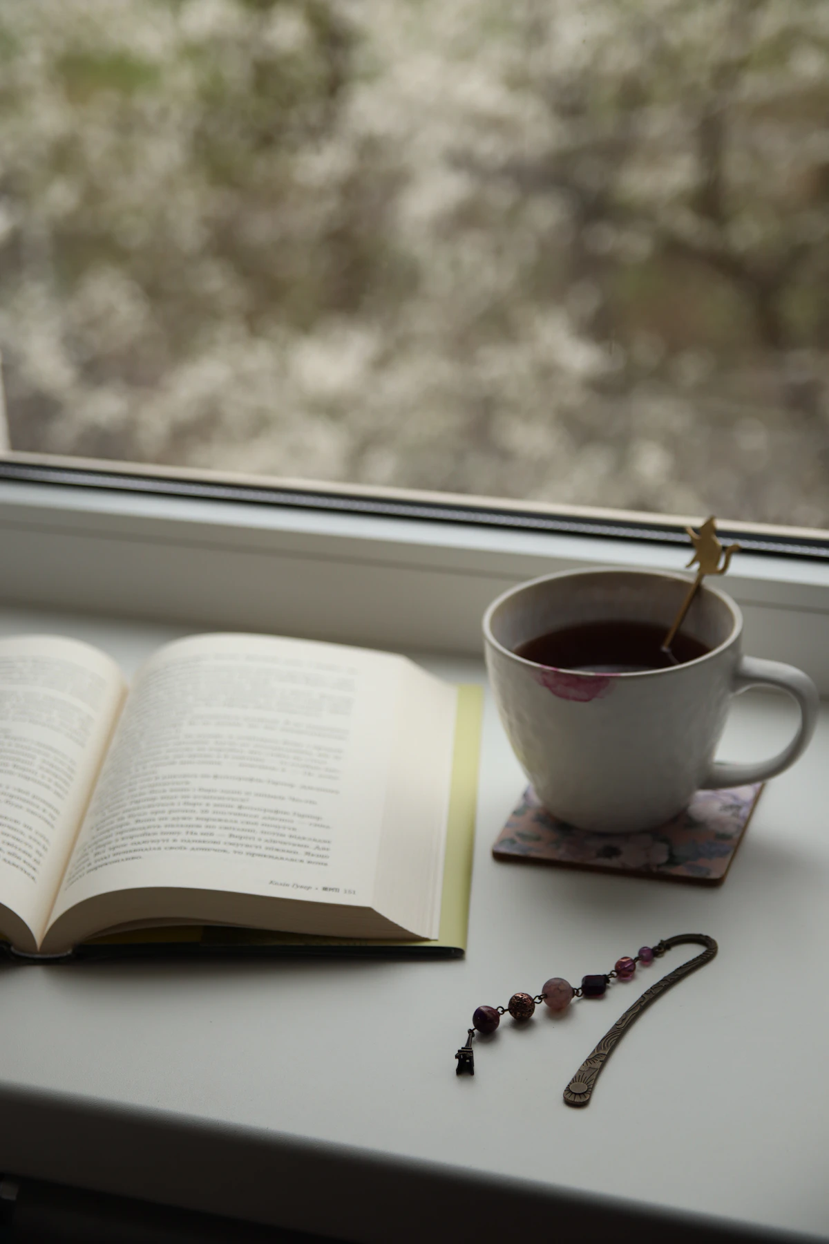 Tasse und Buch am Fenster als ruhiges rauchfreies Abendritual