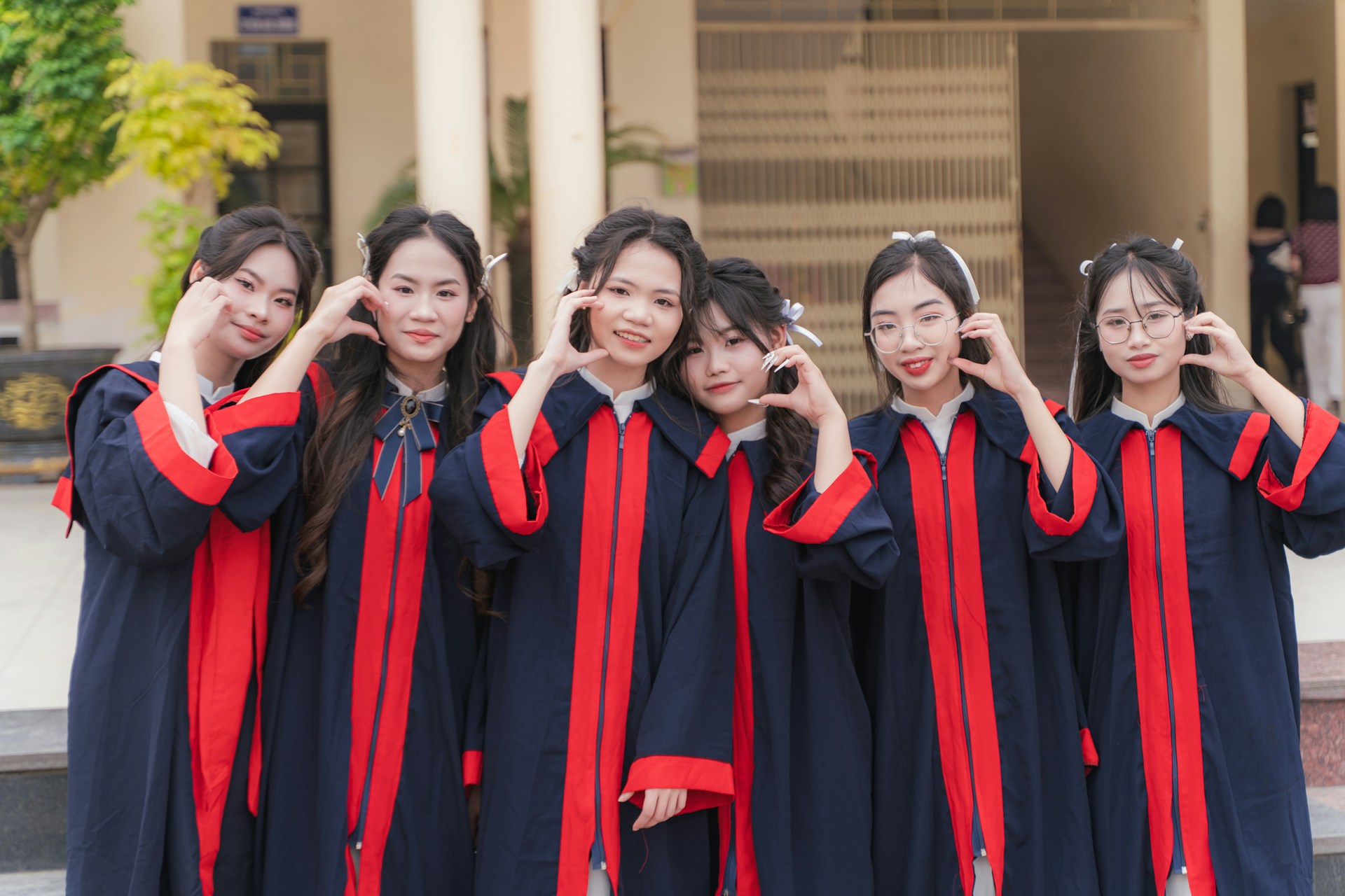 Graduates pose with heart hands.