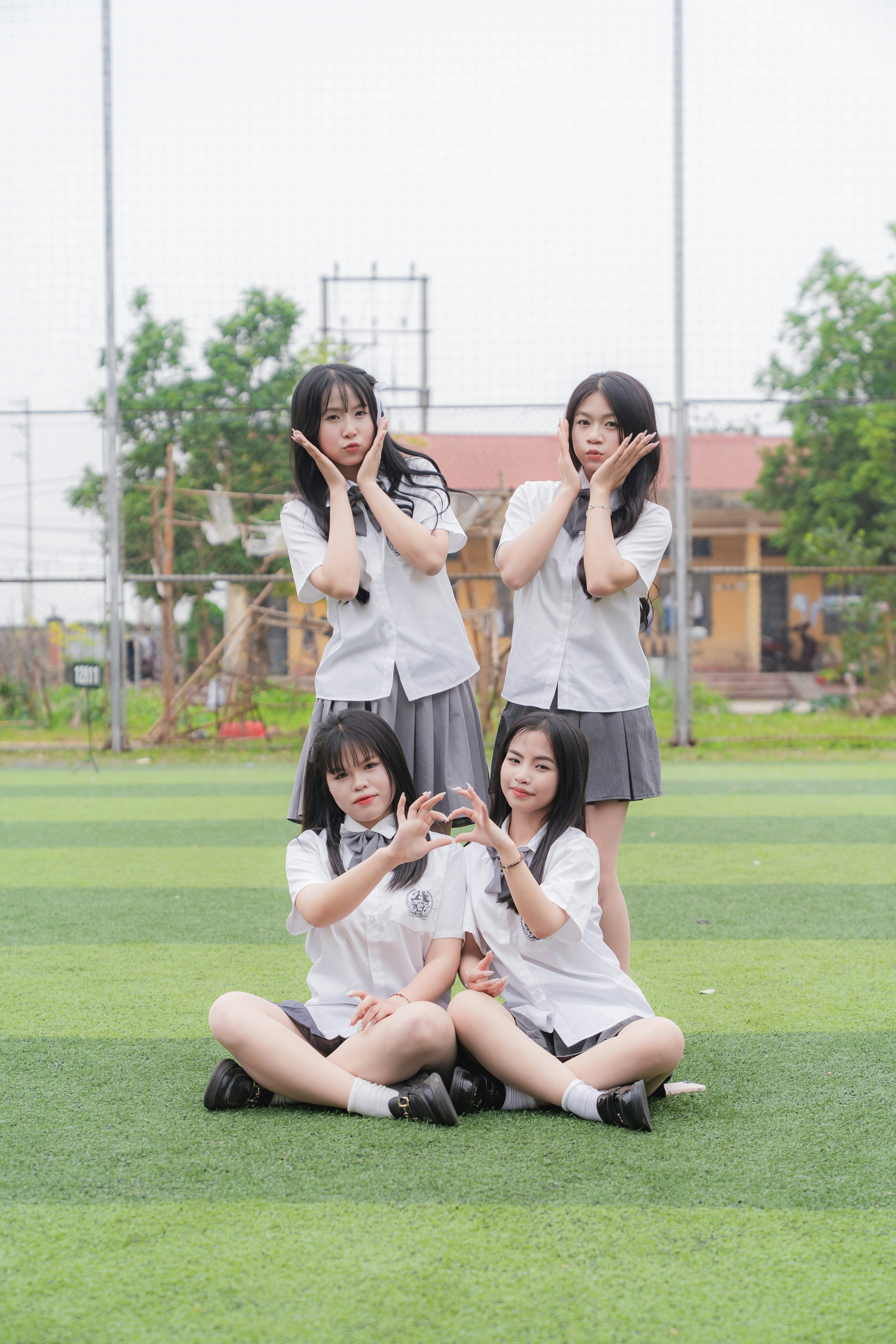 Schoolgirls pose for a photo on a field.