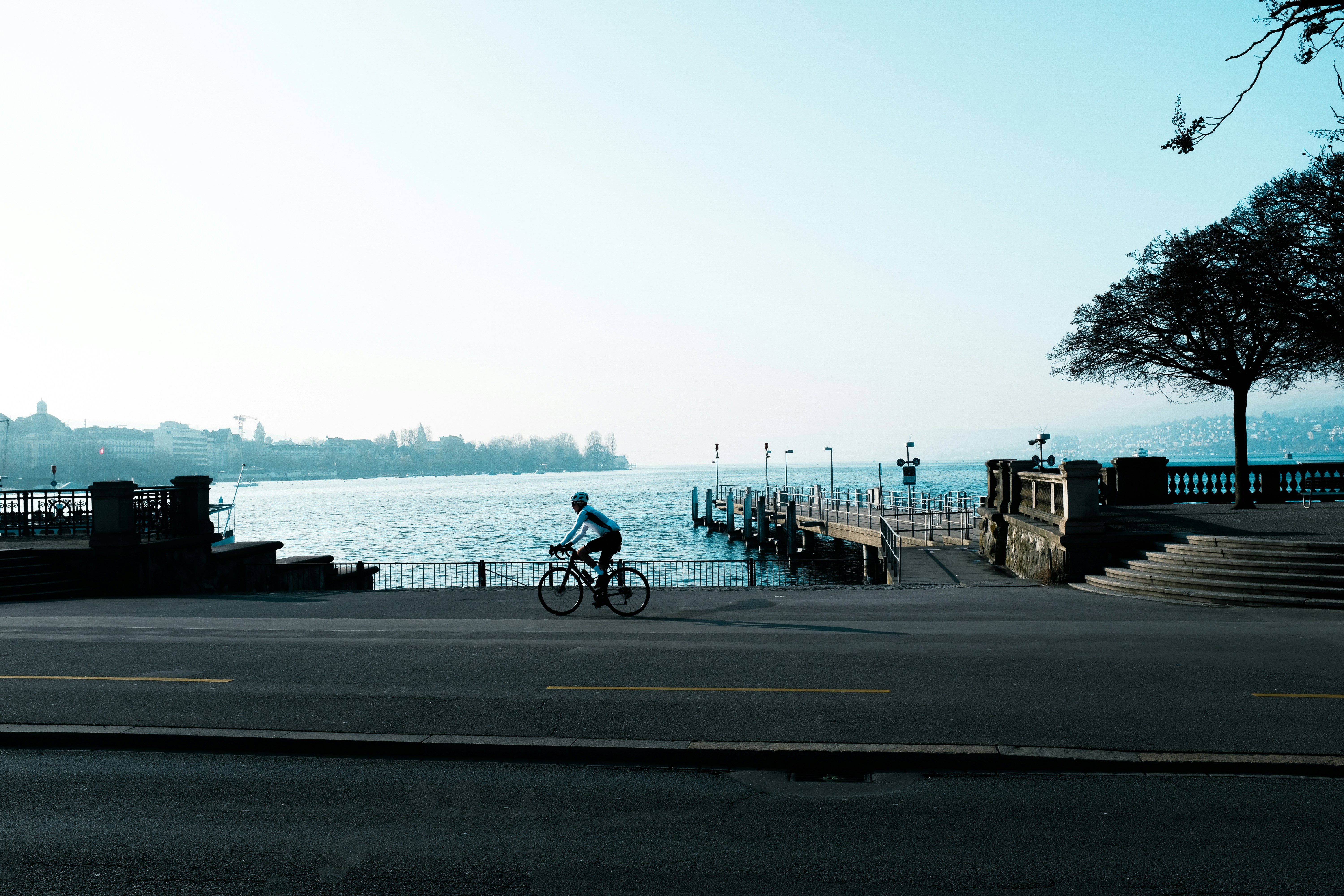 A person rides a bike near the lake.