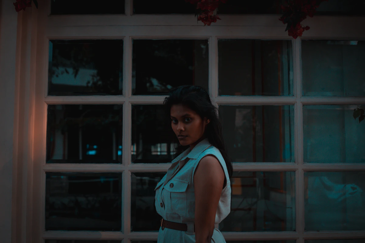 Cinematic dusk still of a woman by a window