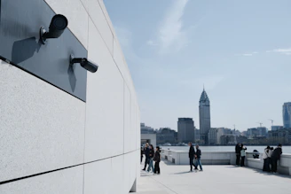 Surveillance cameras on a modern building overlook the city.