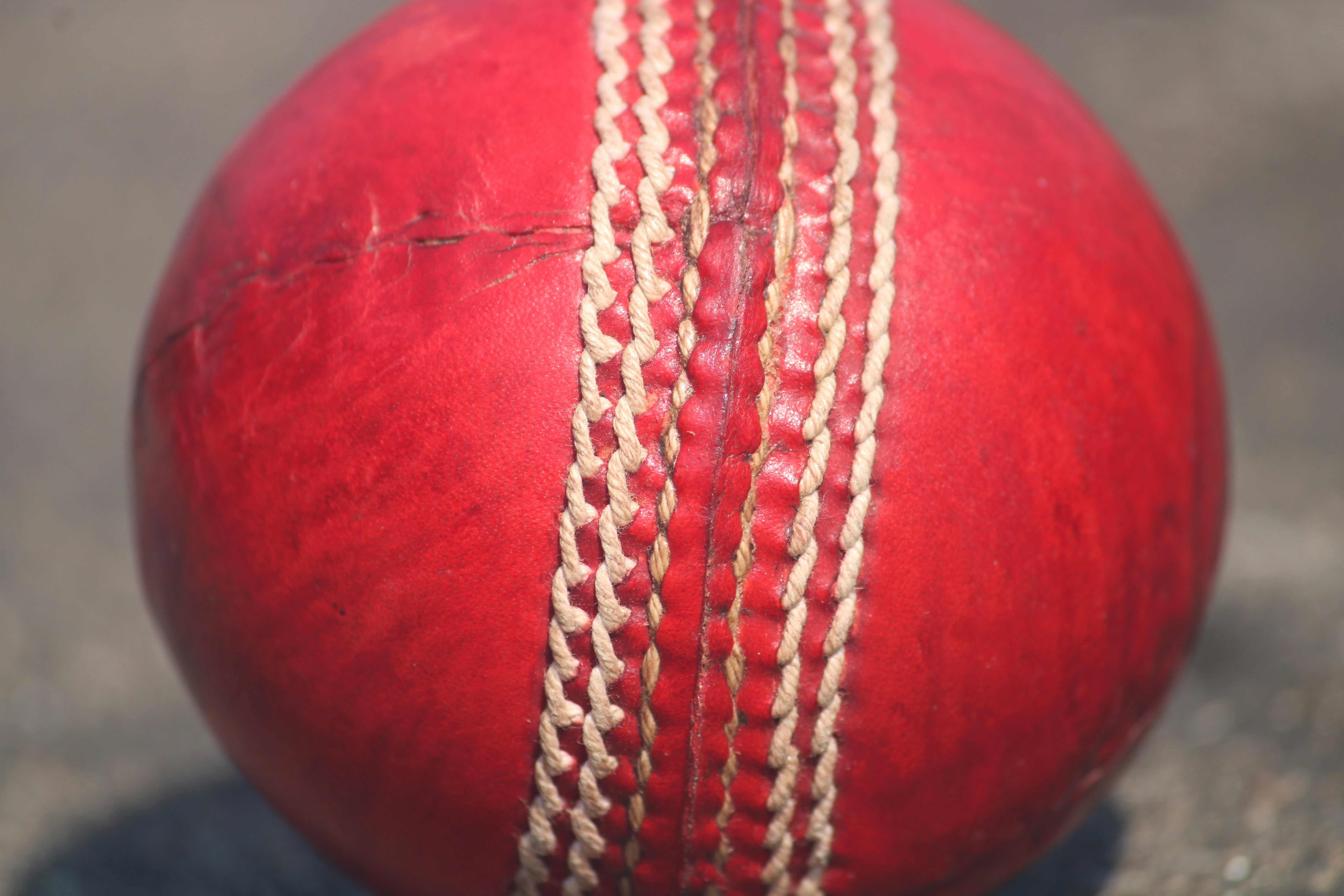 Un primer plano de una pelota de cricket roja.