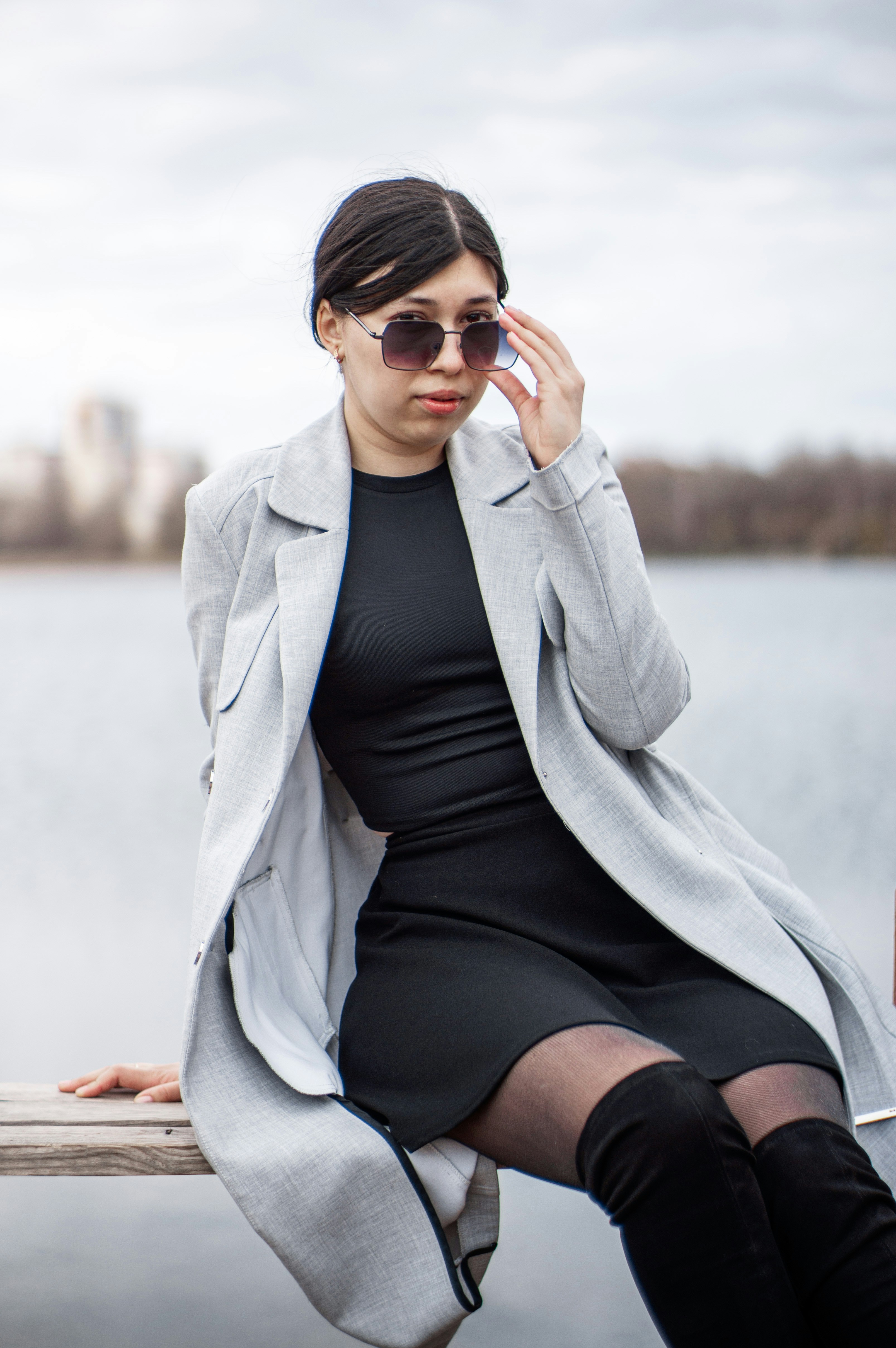 Frau posiert vor einem See.