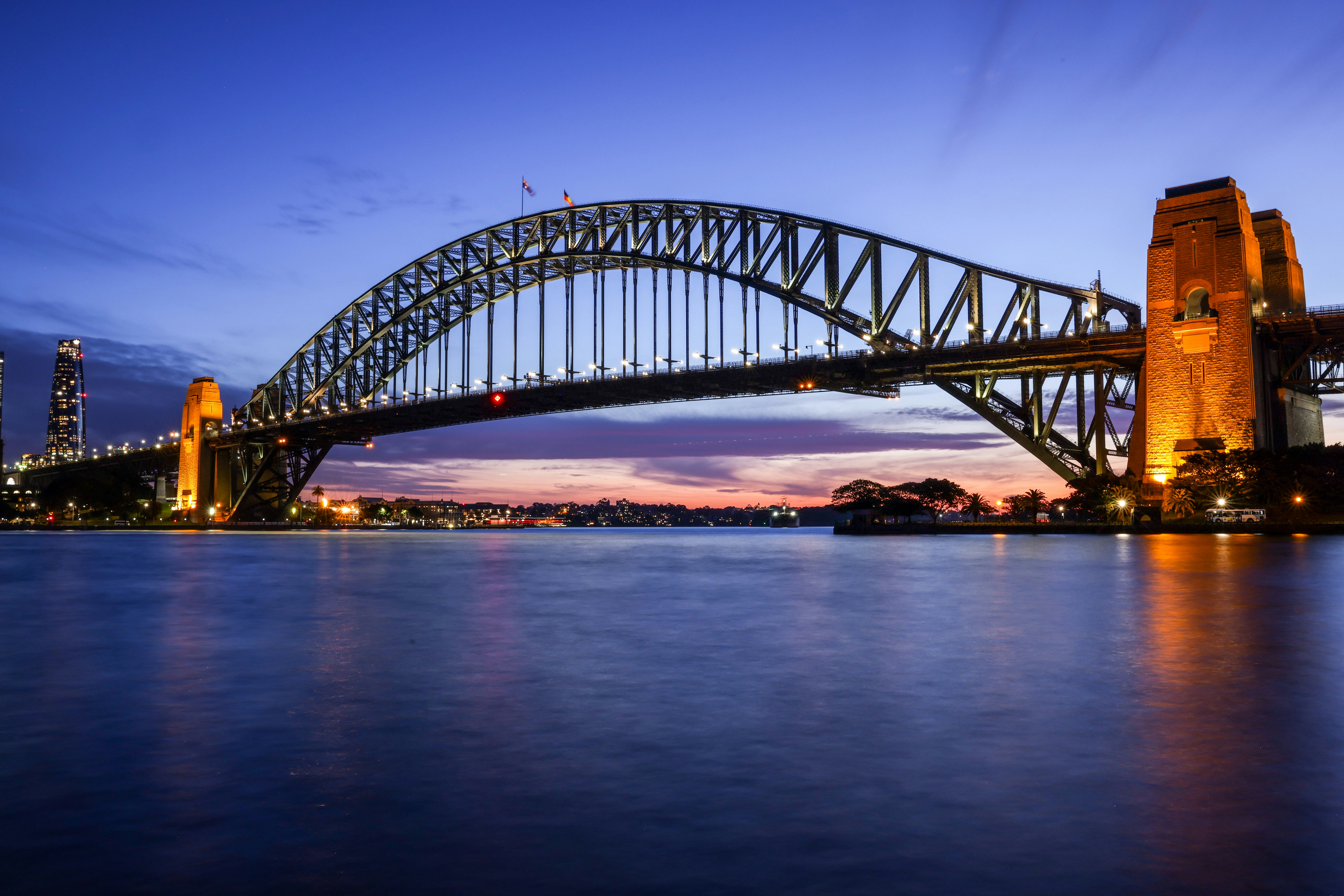 Sydney harbour bridge illuminated at dusk.