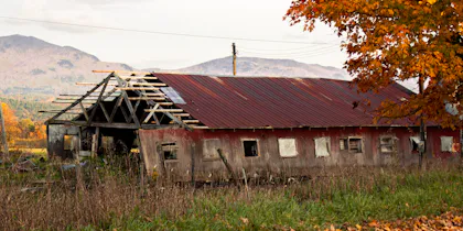 Weathered barn against autumn foliage