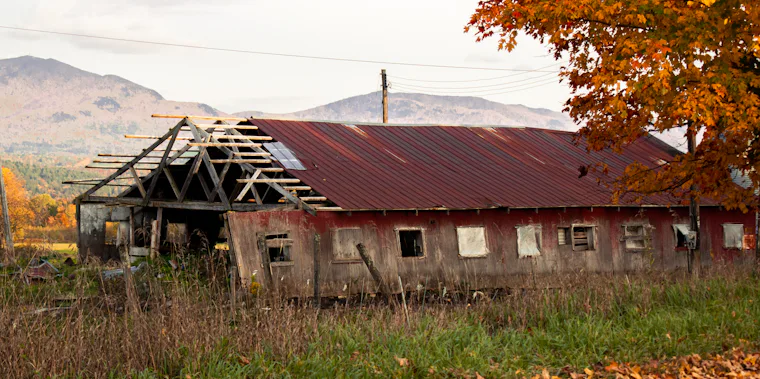 Weathered barn against autumn foliage