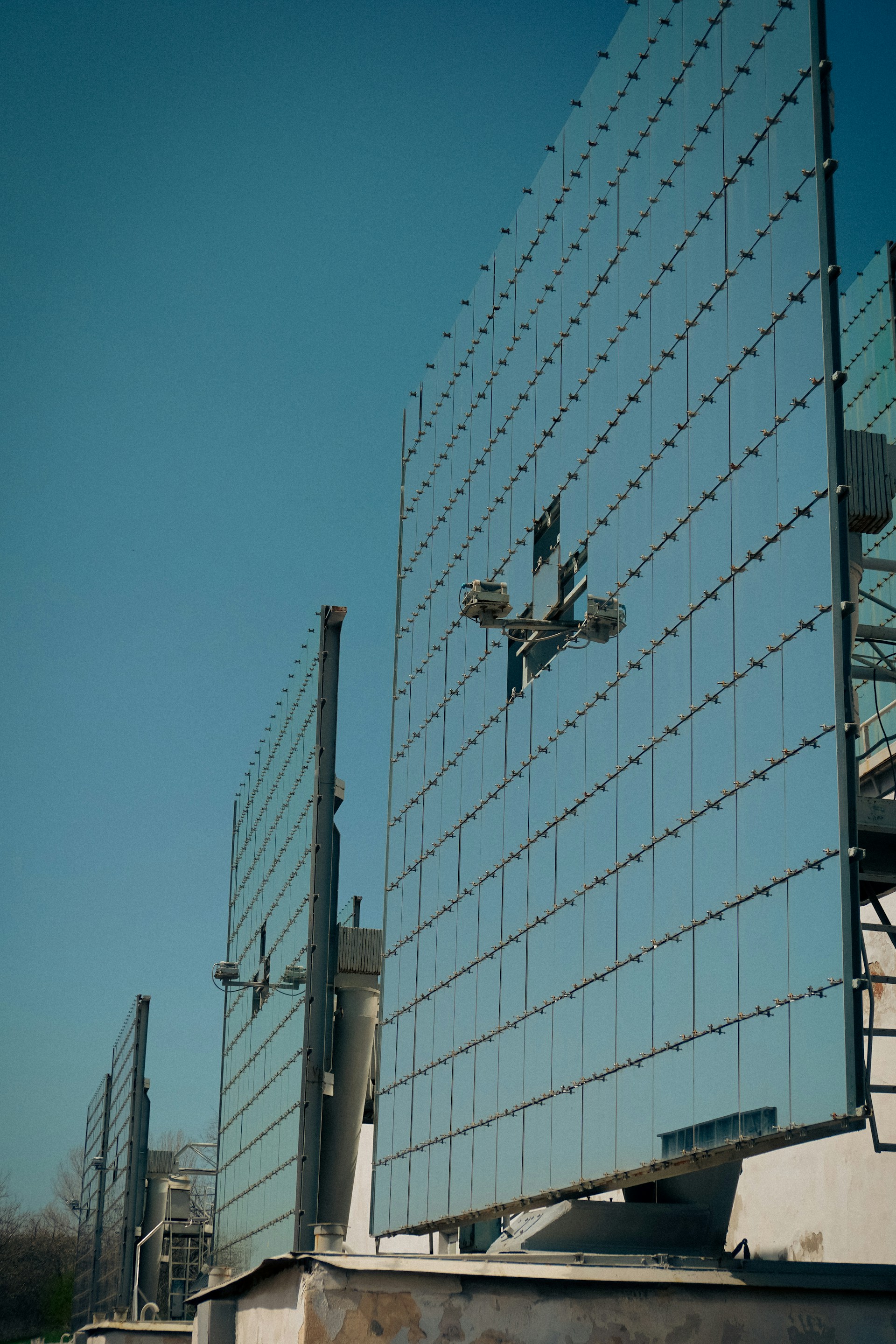 Solar panels shine brightly against a clear blue sky.