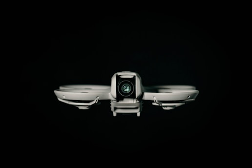 A drone faces the viewer against a black background.