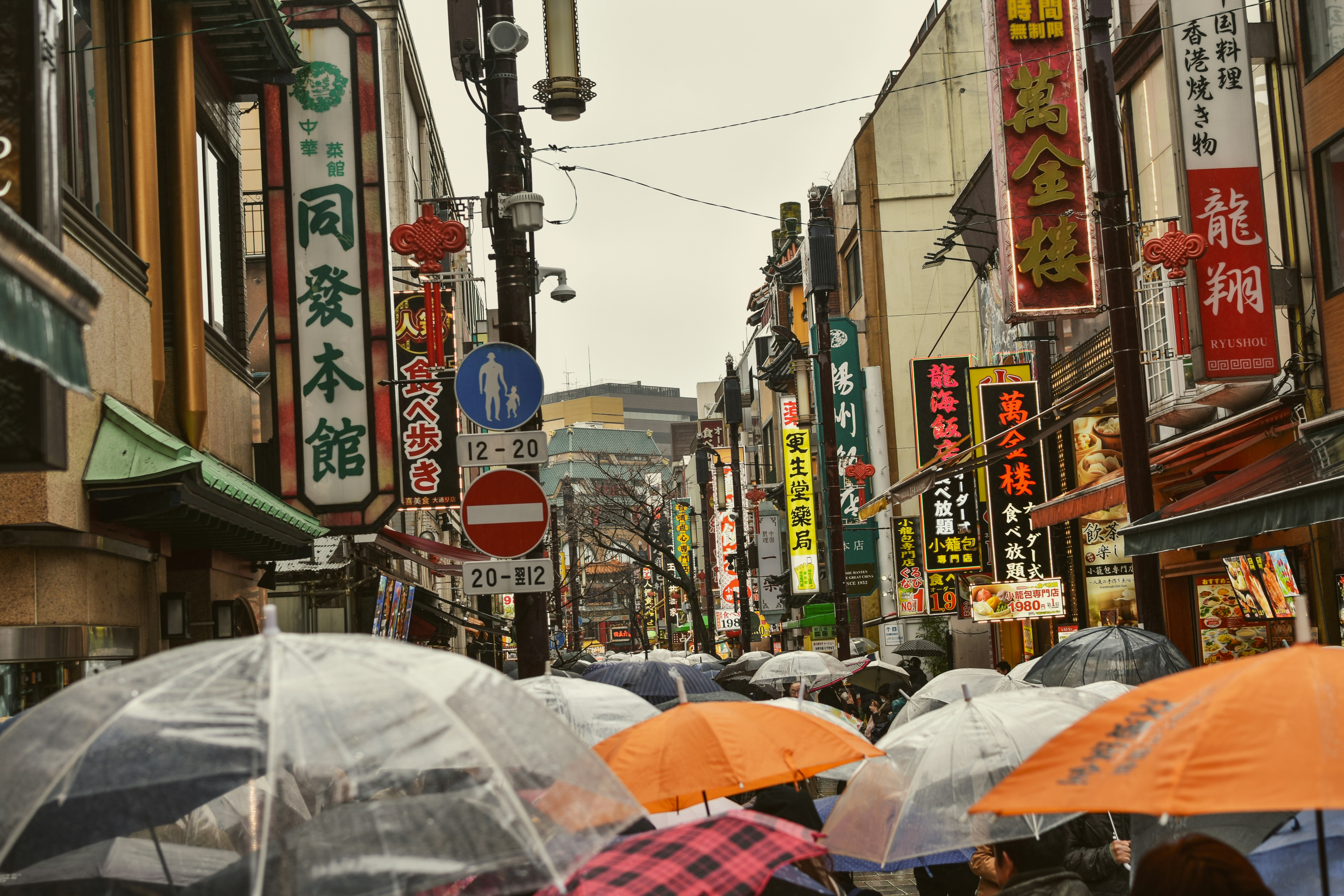A crowded street in an asian city on a rainy day.