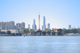 A city skyline is seen across calm waters.
