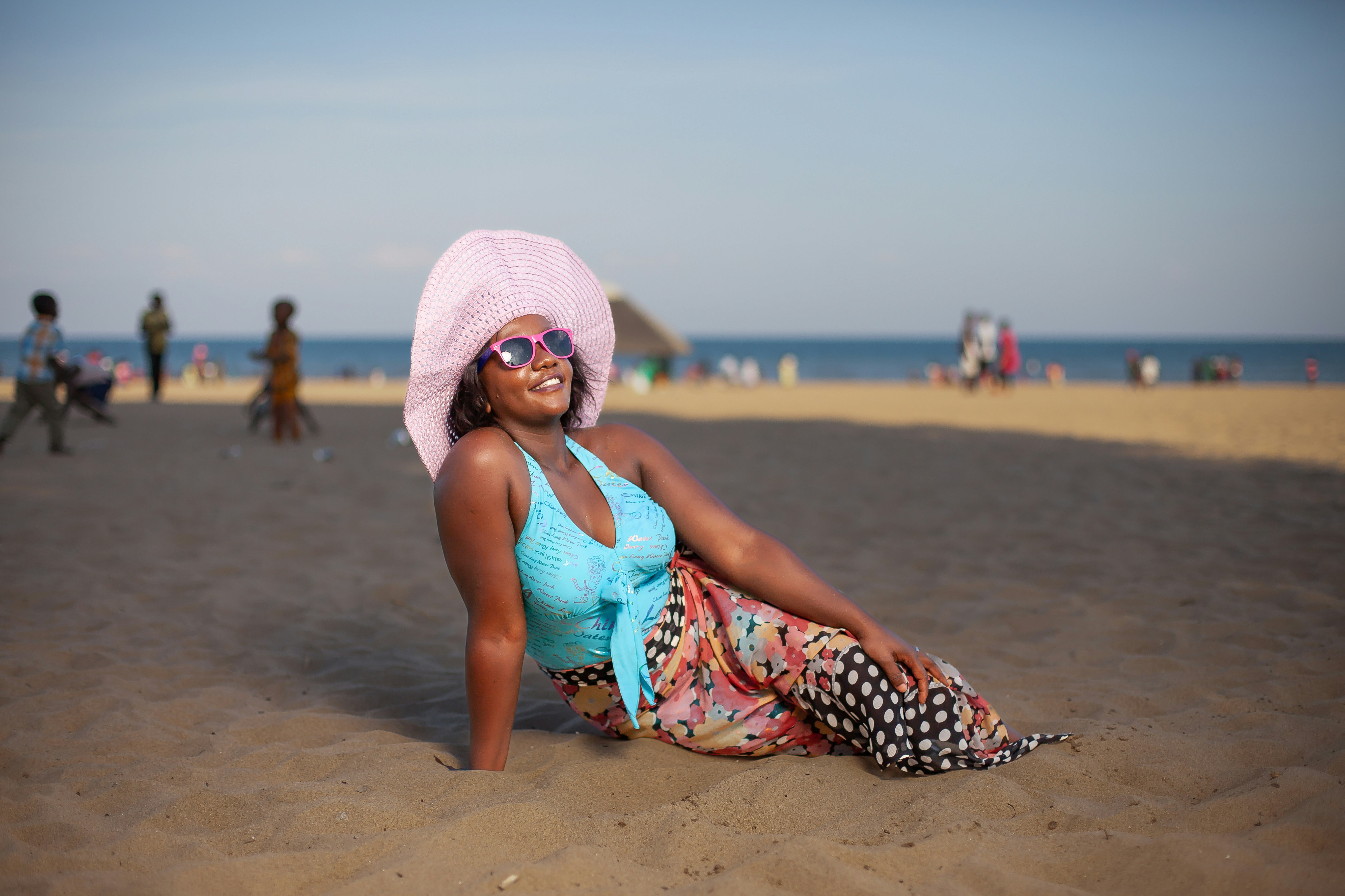 Woman relaxes on the beach, smiling.