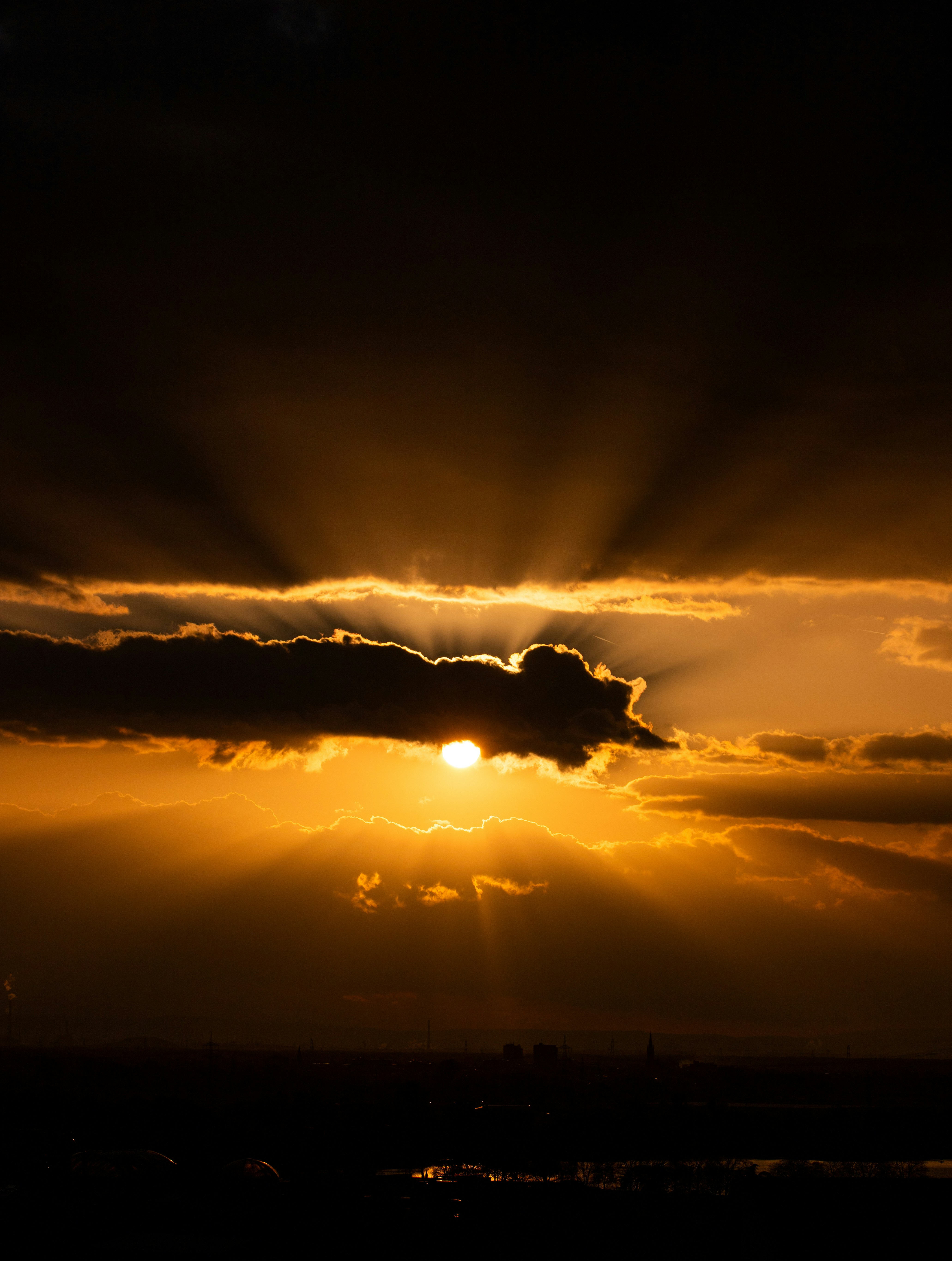 The sun shines through the clouds over a city photo – Free Land