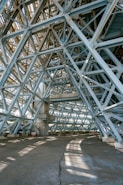Here's a caption: steel beams form an intricate, geometric structure.