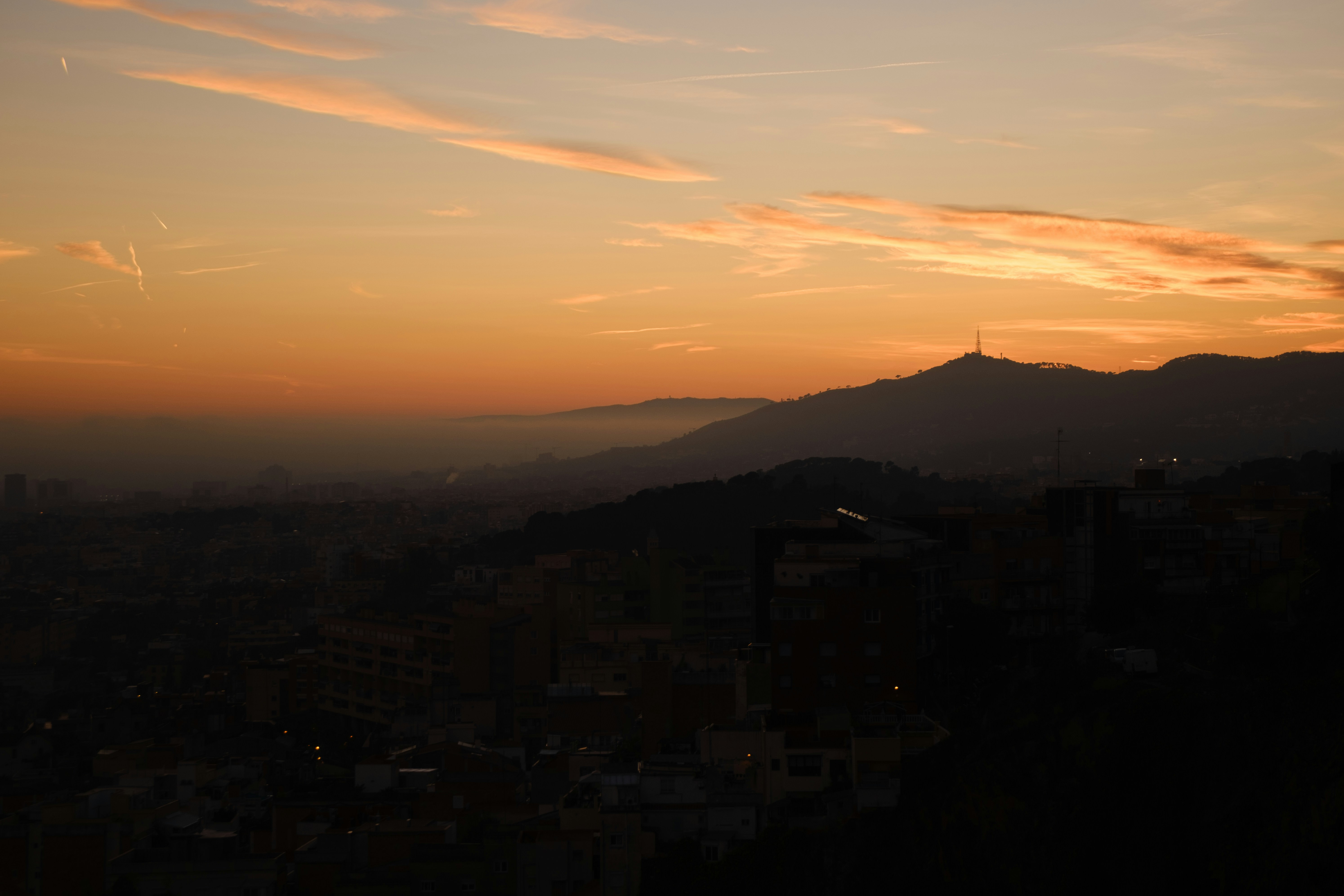Sunset paints the sky over distant mountains.