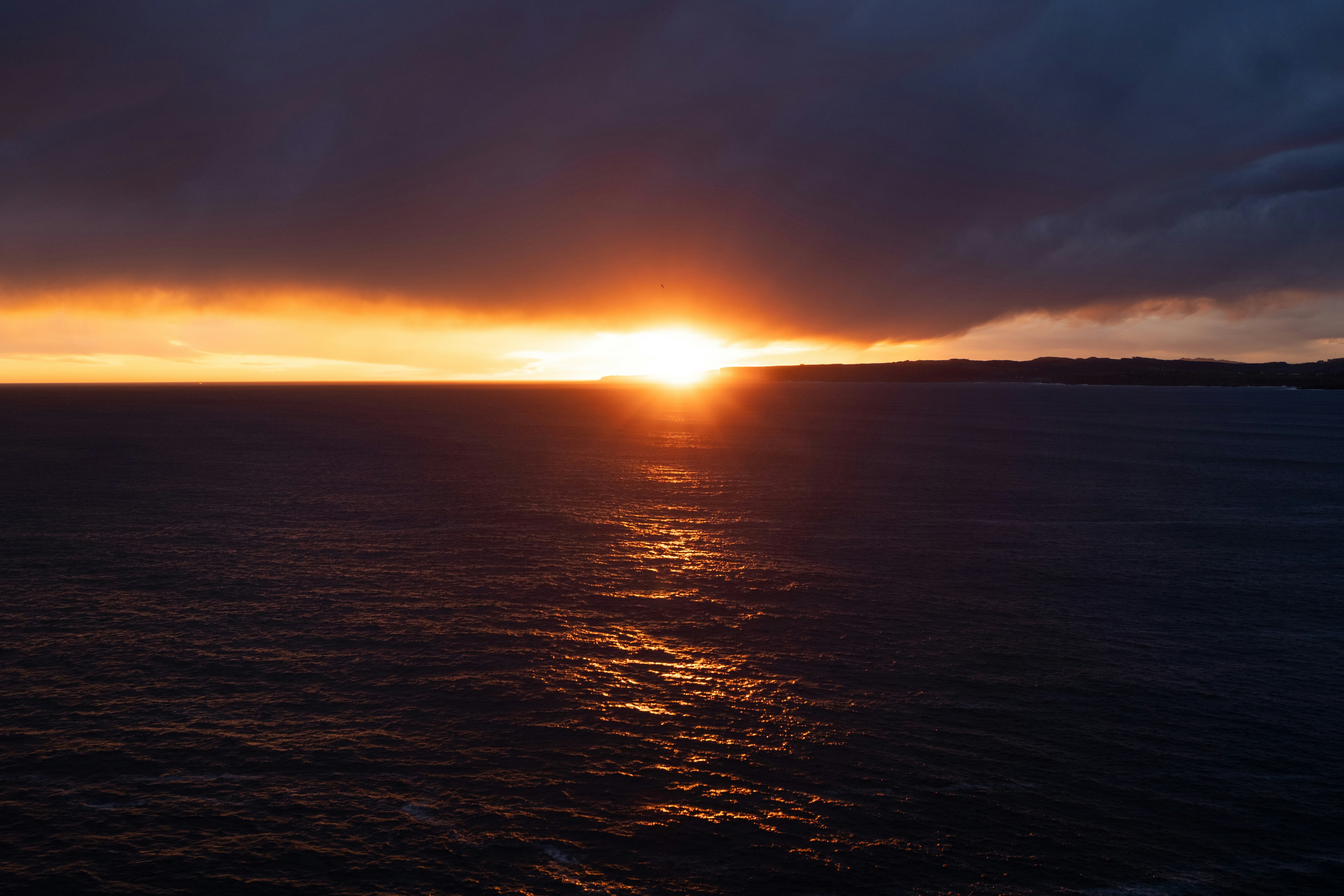 Sunset illuminates the ocean's surface.