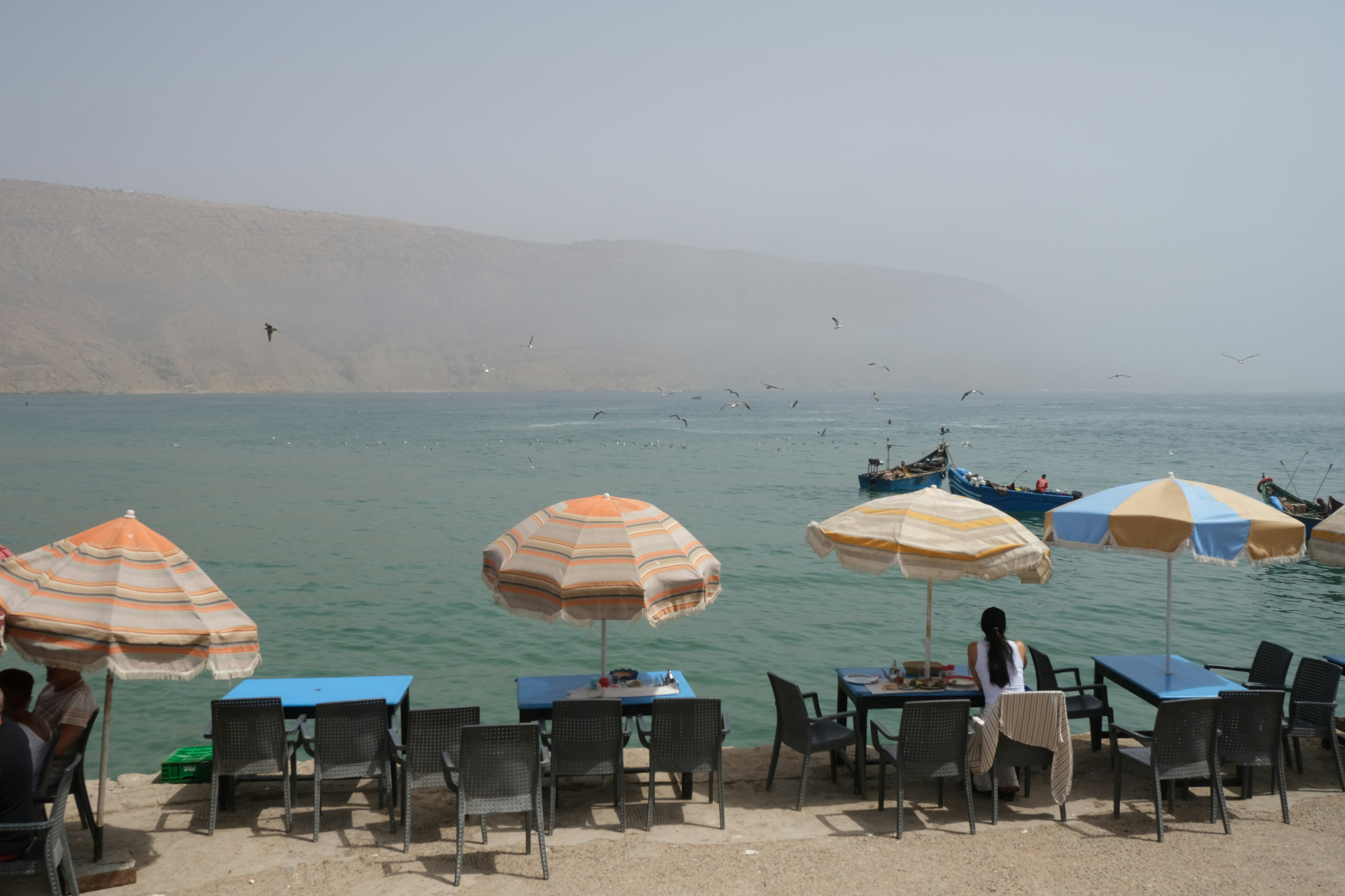Beach umbrellas overlook a serene seaside landscape.
