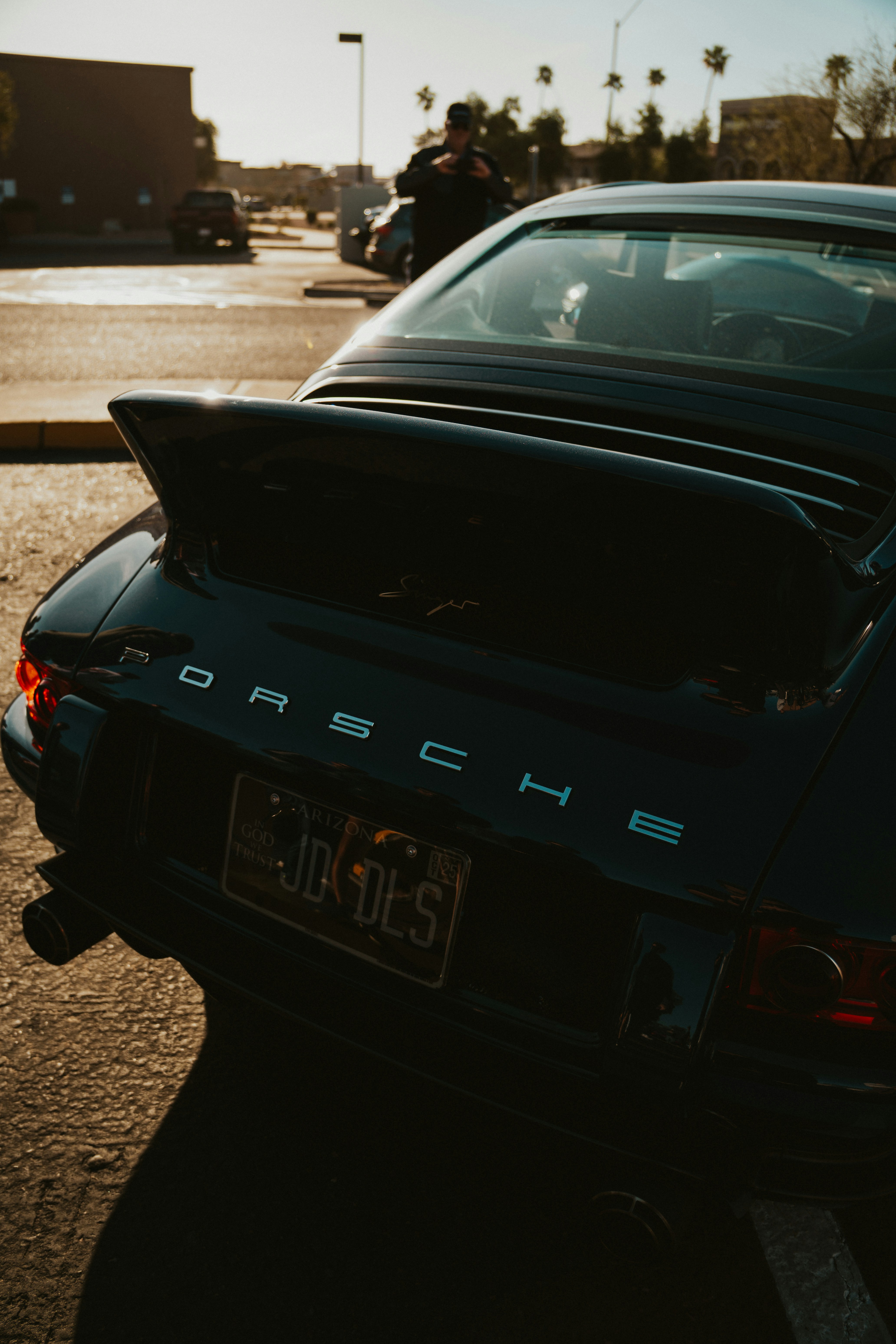 A black porsche is parked and ready.