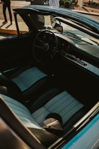 Inside the classic car: steering wheel, seats, and dashboard.