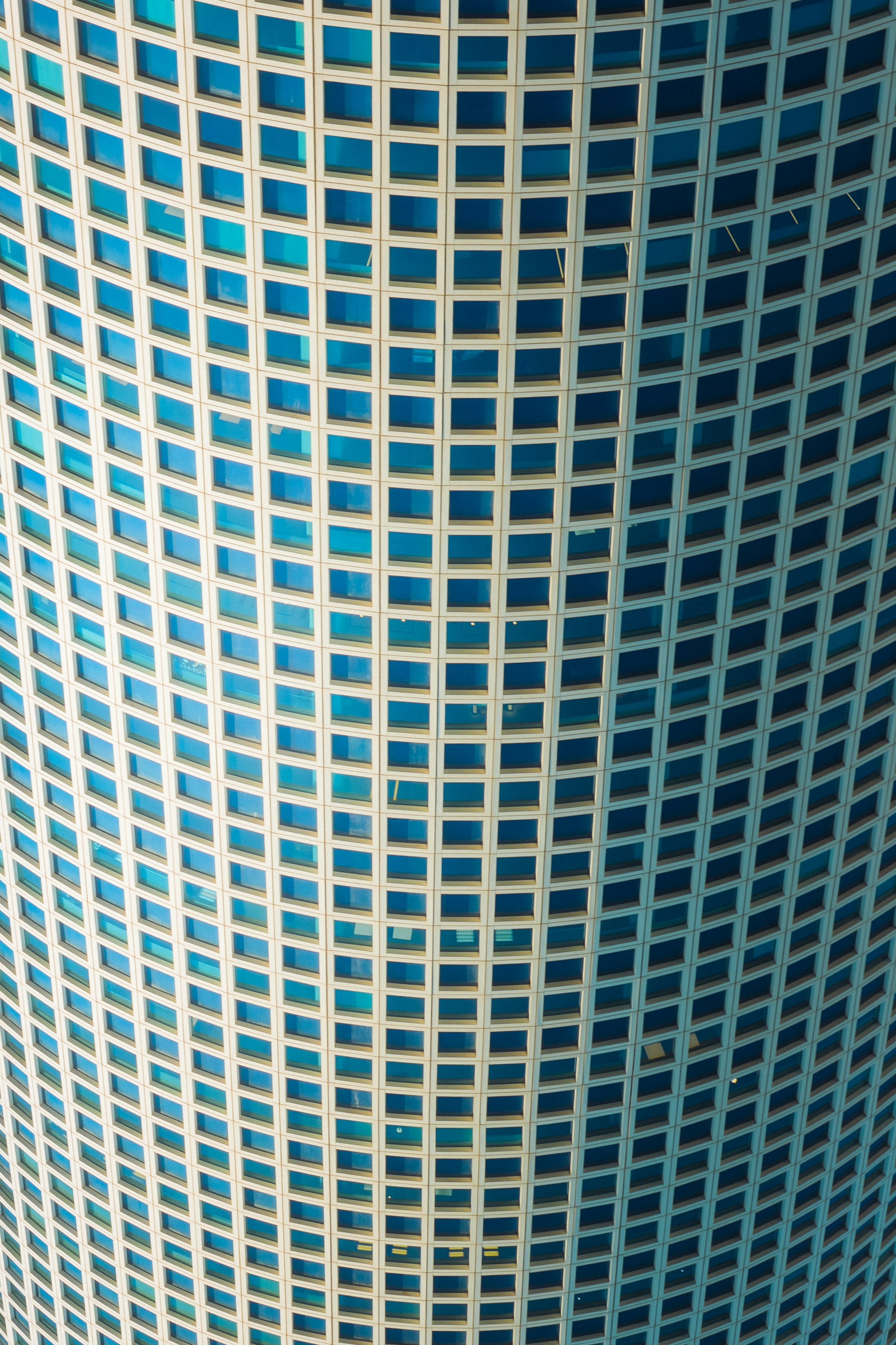 A skyscraper with many blue square windows.
