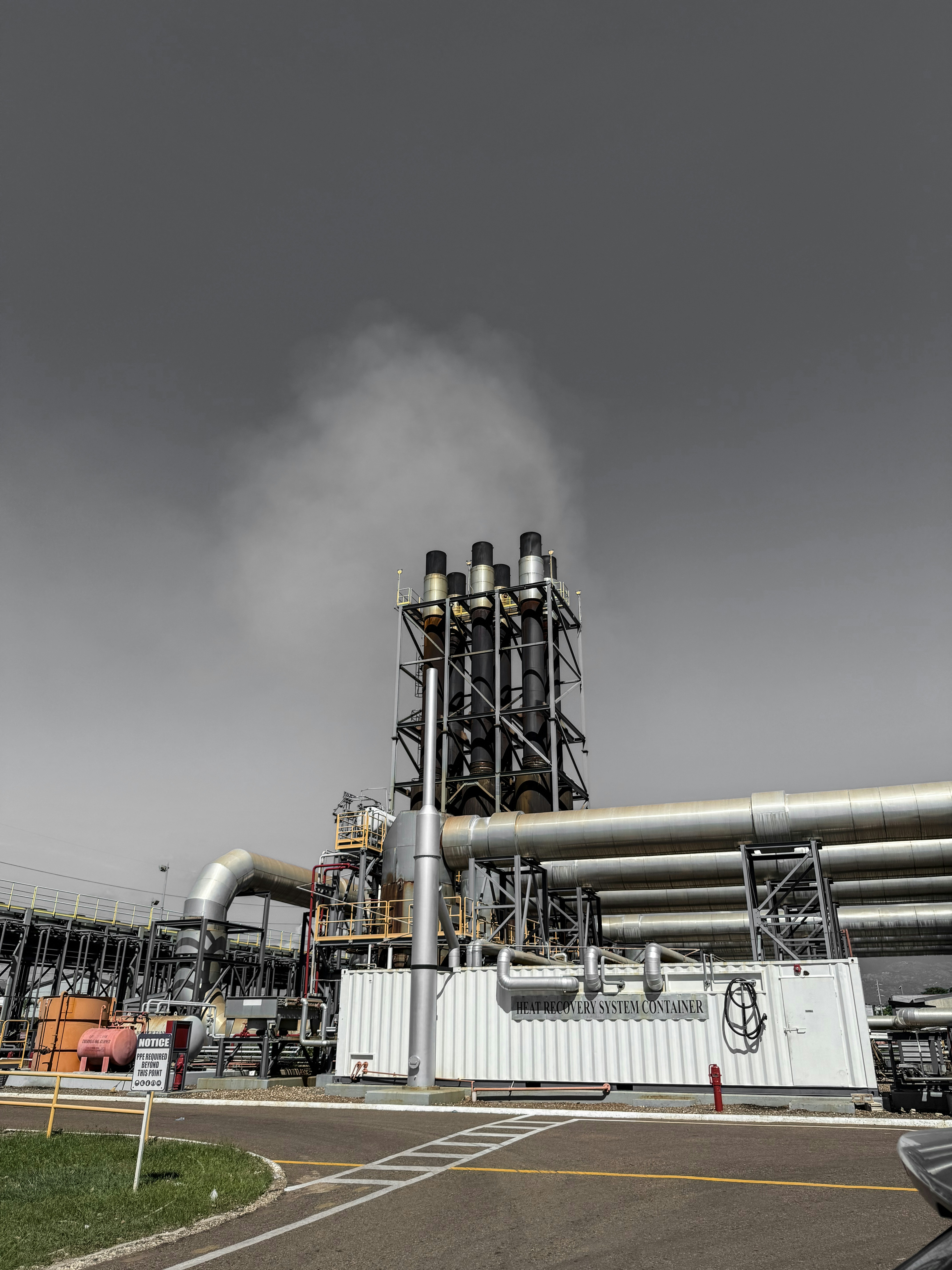 Industrial smokestacks releasing steam into the sky.