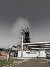 Industrial smokestacks releasing steam into the sky.