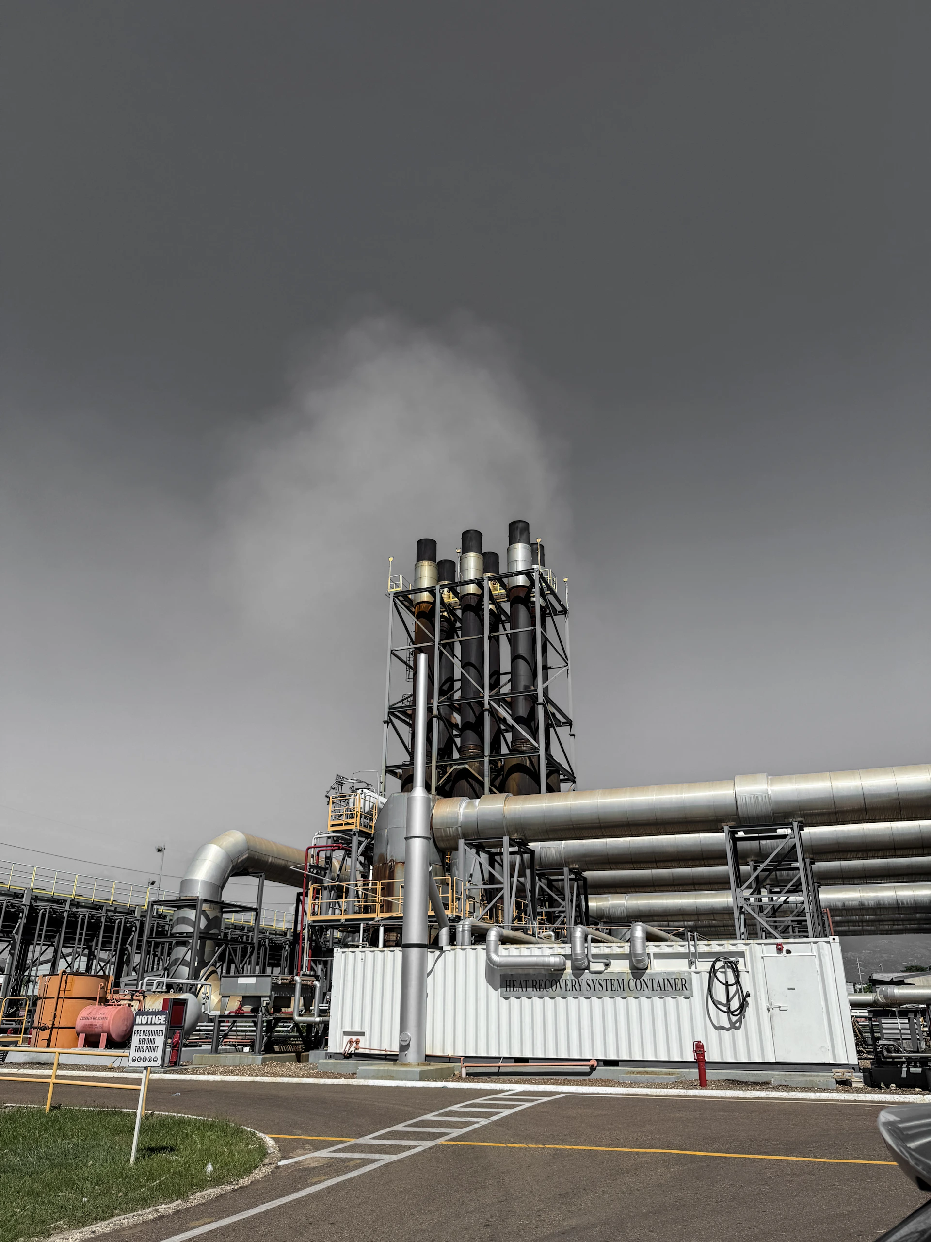 Industrial smokestacks releasing steam into the sky.