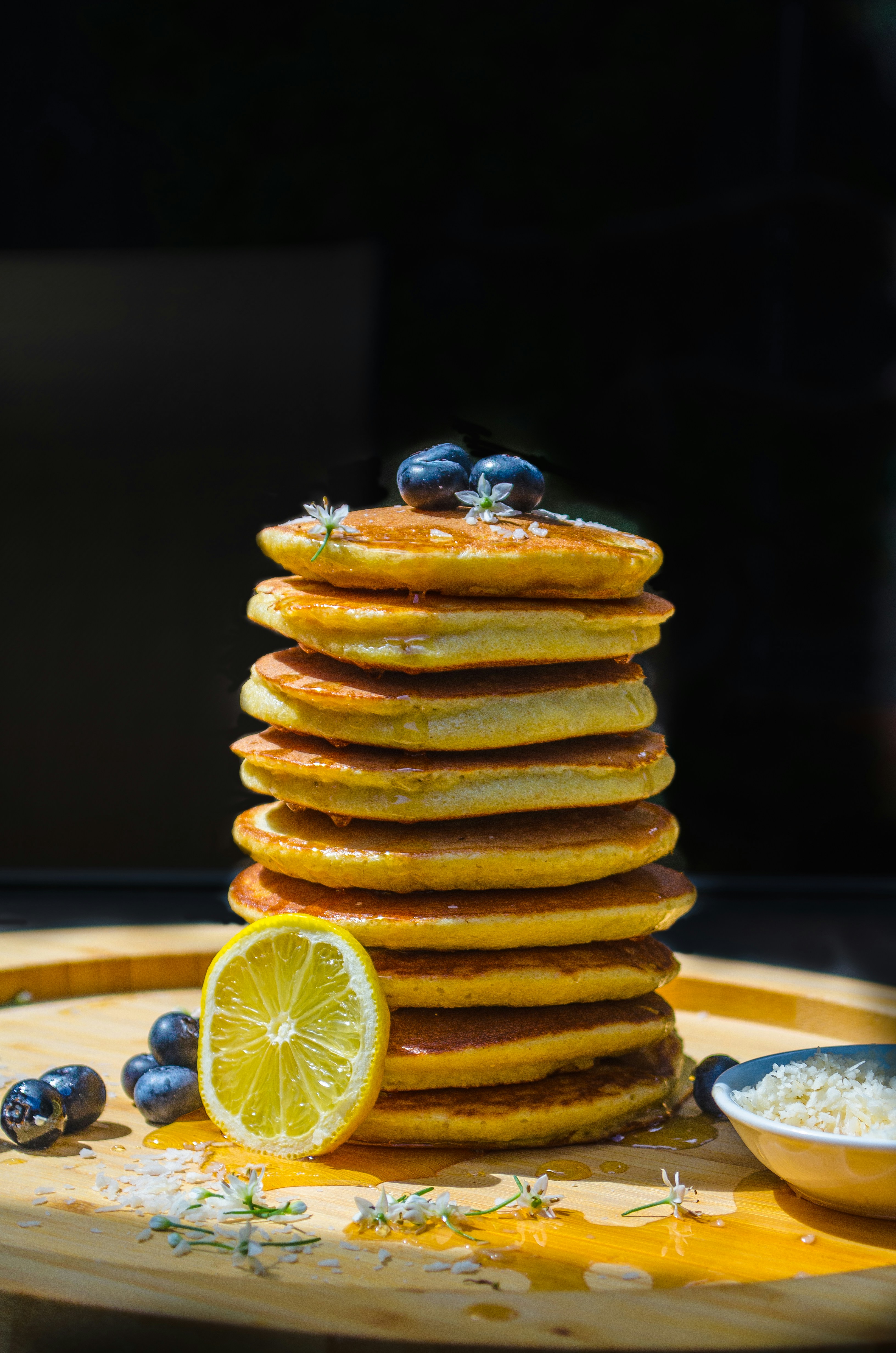 Delicious pancakes stacked high with berries and lemon.