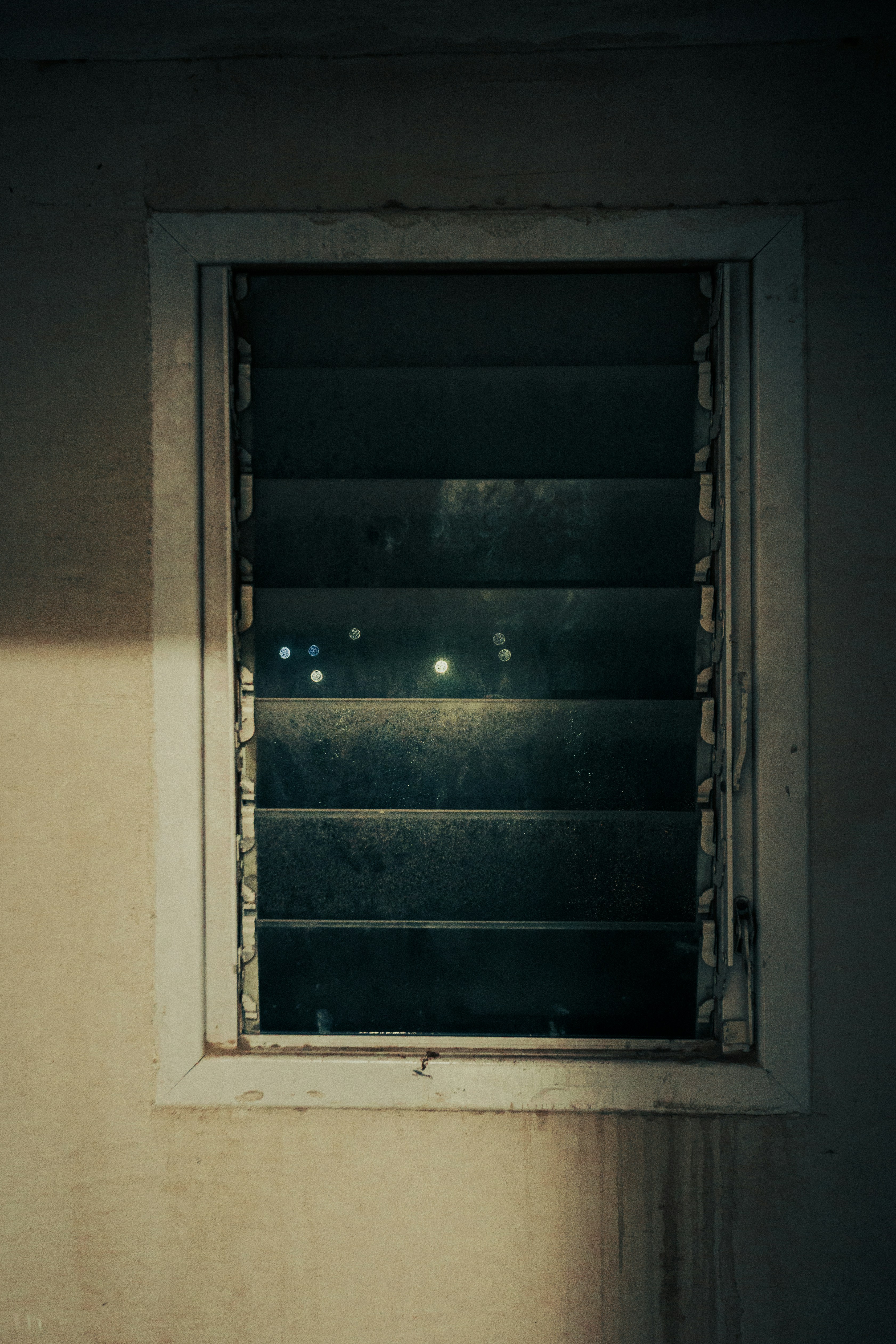 A darkened window with light peeking through.