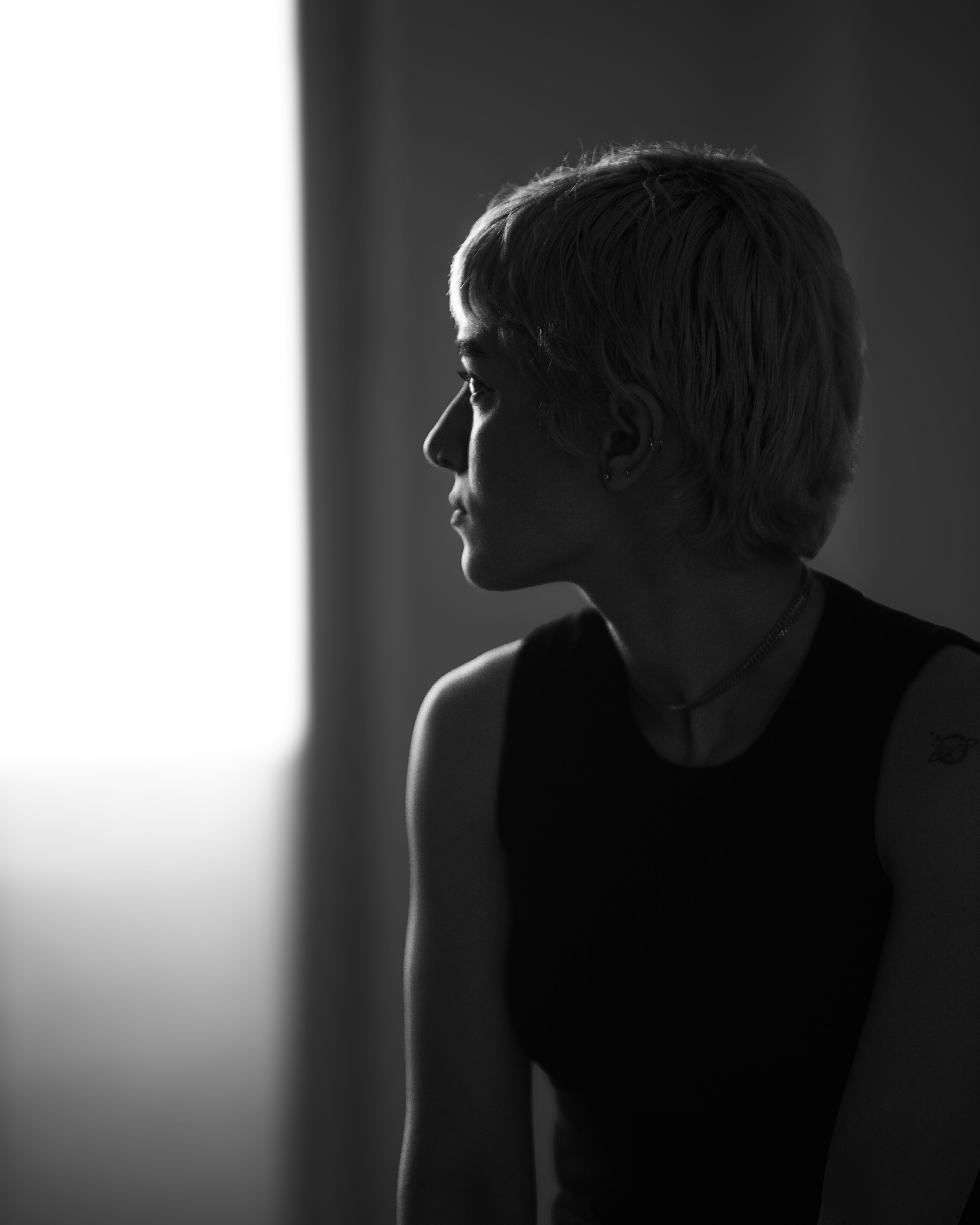 横顔の女性は、思慮深く光を見つめています。