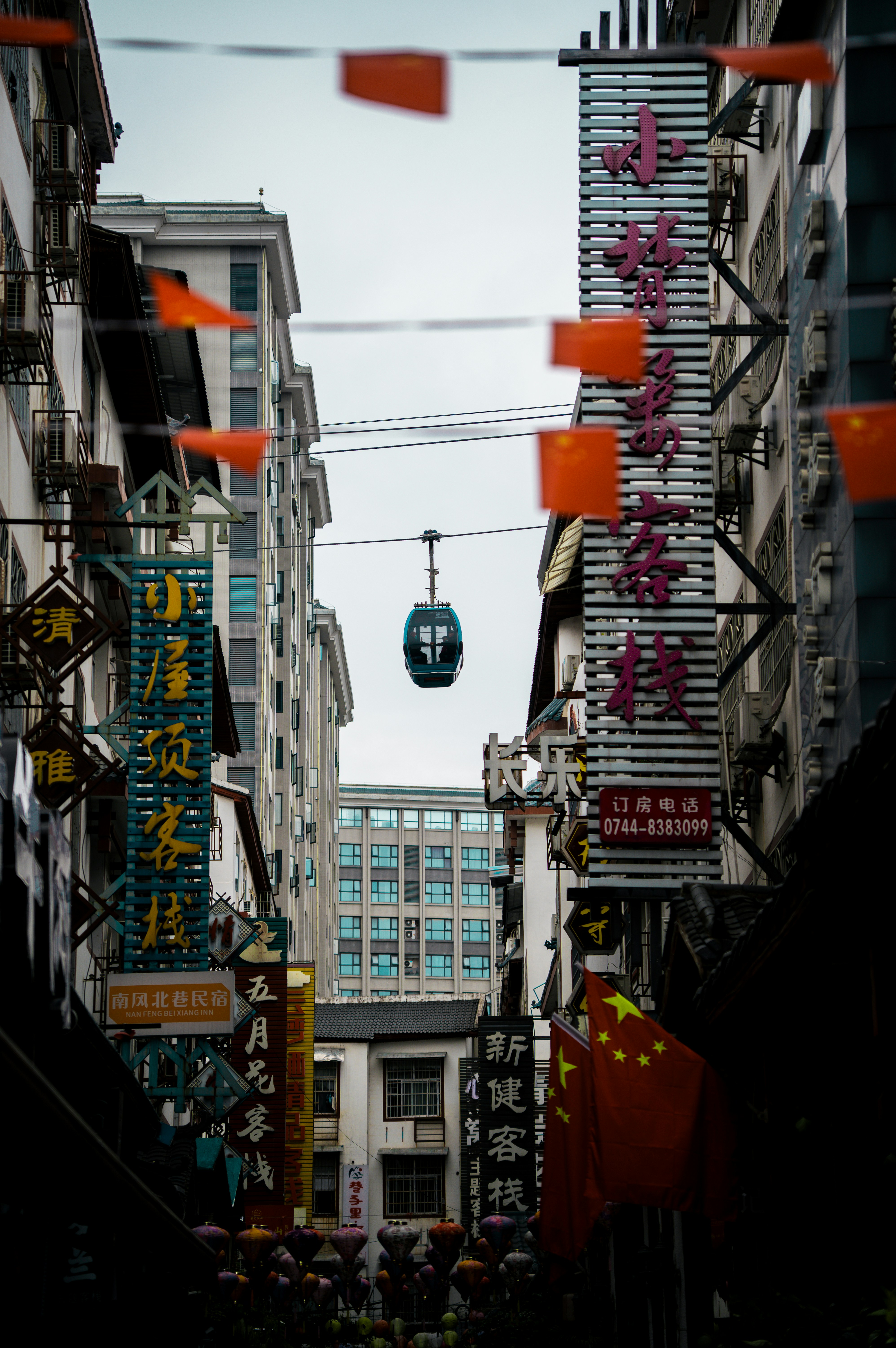 Un teleférico se desliza sobre una concurrida calle de la ciudad.
