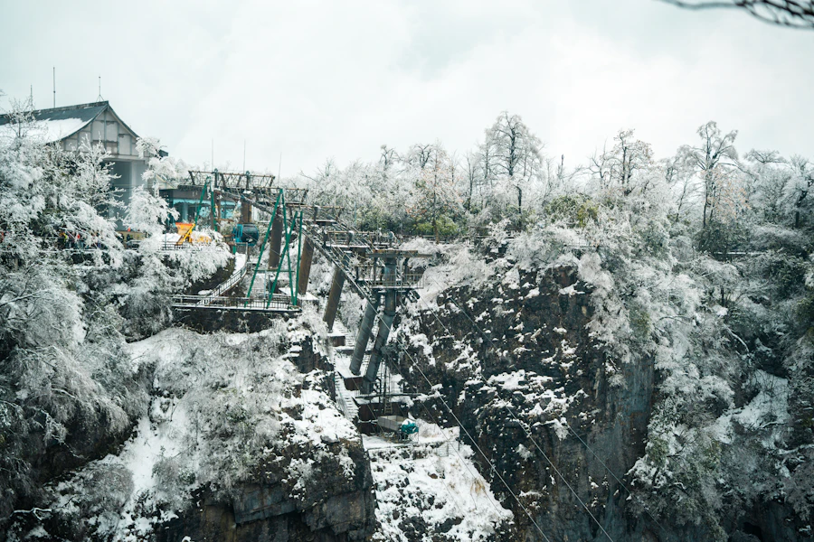 Cliffside wooden structures and pathway dusted with winter snow at Tianmen Mountain