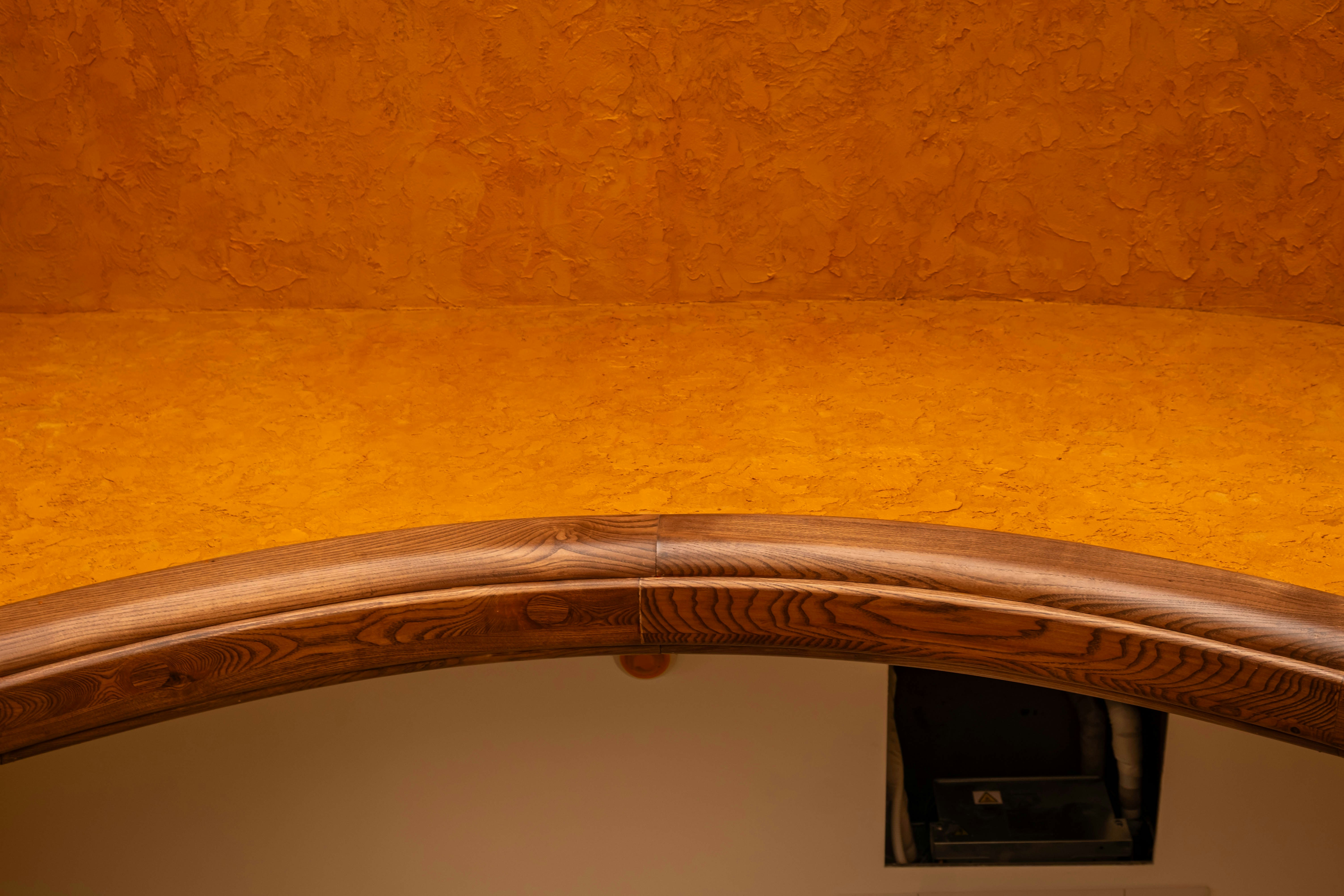 A wooden archway and textured wall