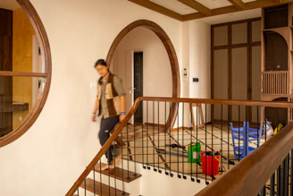 Man walks down stairs inside a stylish home.
