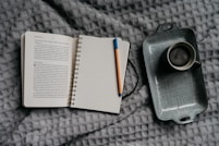 Coffee and journal on a bed.
