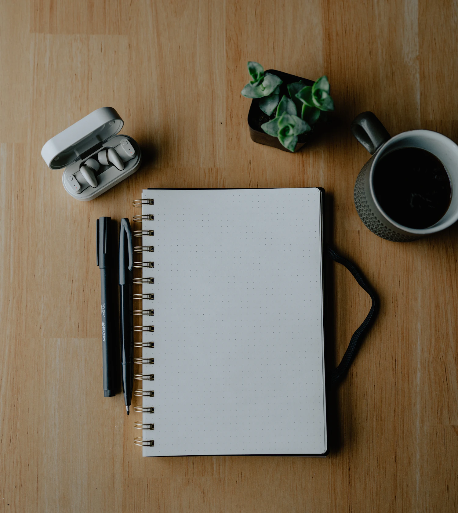 Coffee, notebook, and a quiet moment at a wooden table