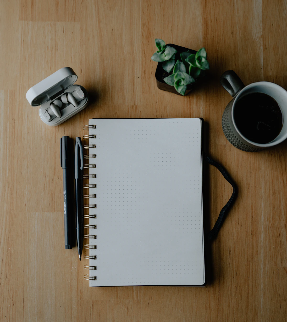 Notizbuch, Stifte und Kaffee auf einem Tisch als Symbol für einen persönlichen Rauchstopp-Plan