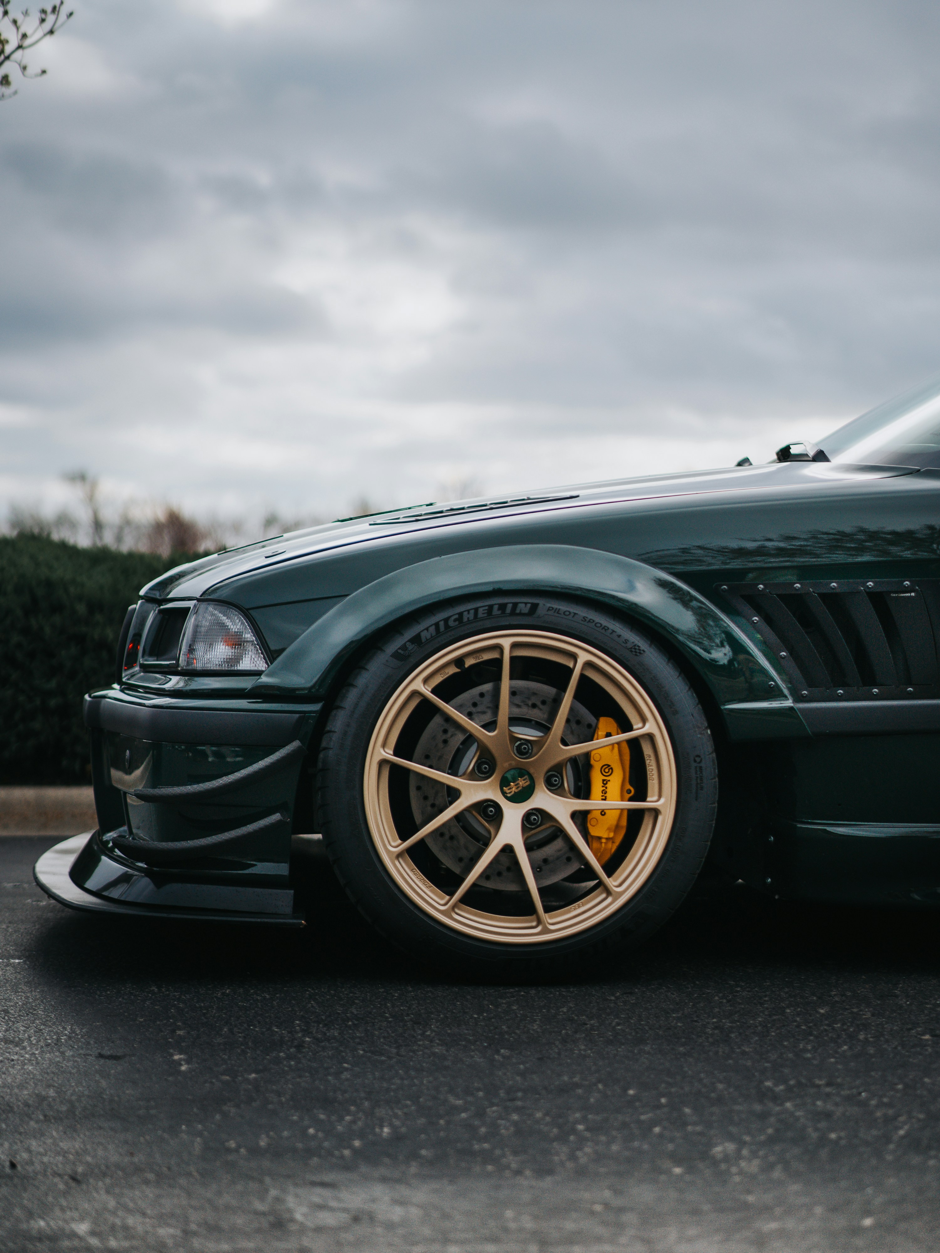 A green BMW with gold rims is shown.