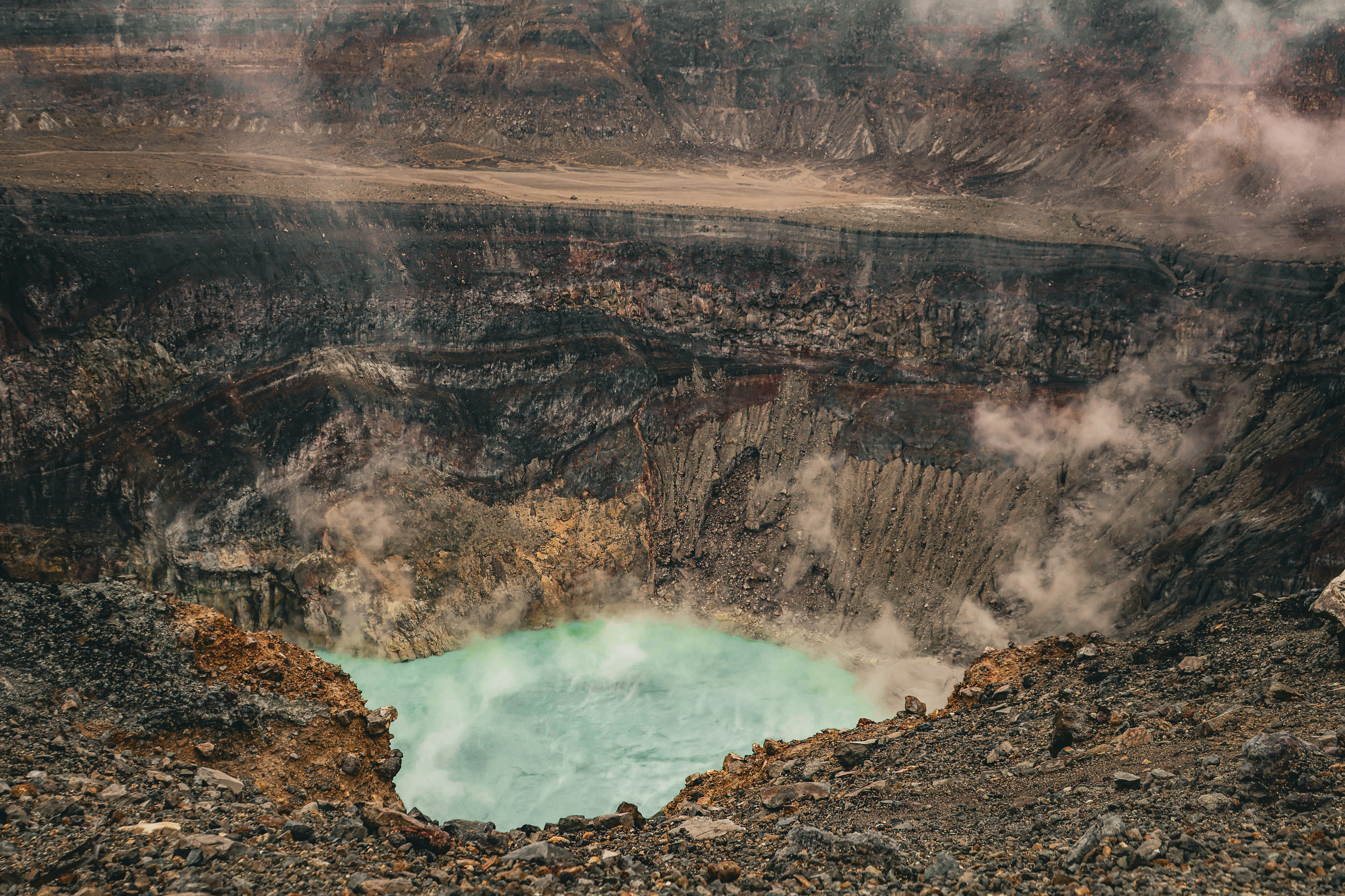 A volcanic crater displays a green-colored lake.