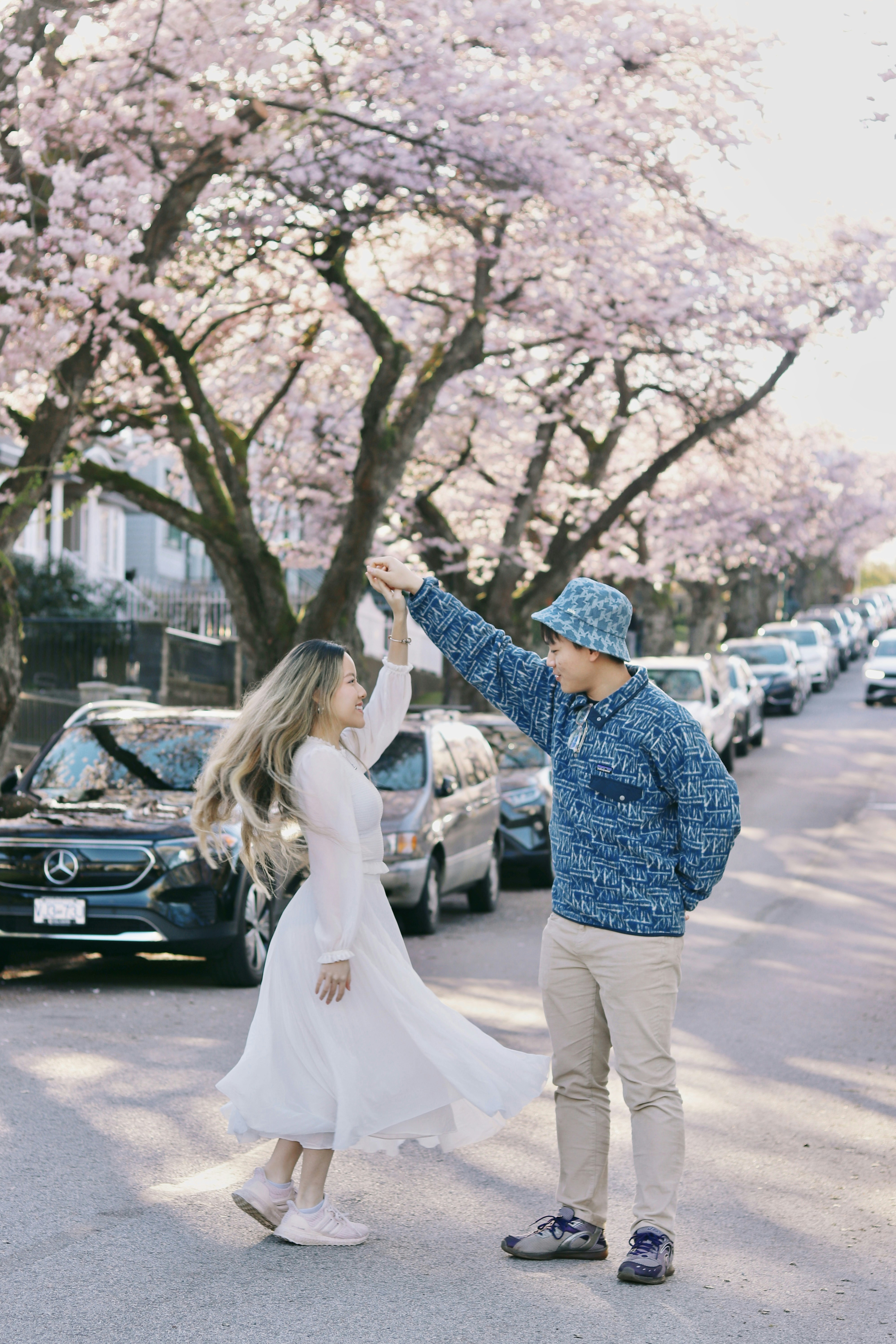 Paar tanzt anmutig unter einem blühenden Kirschbaum.