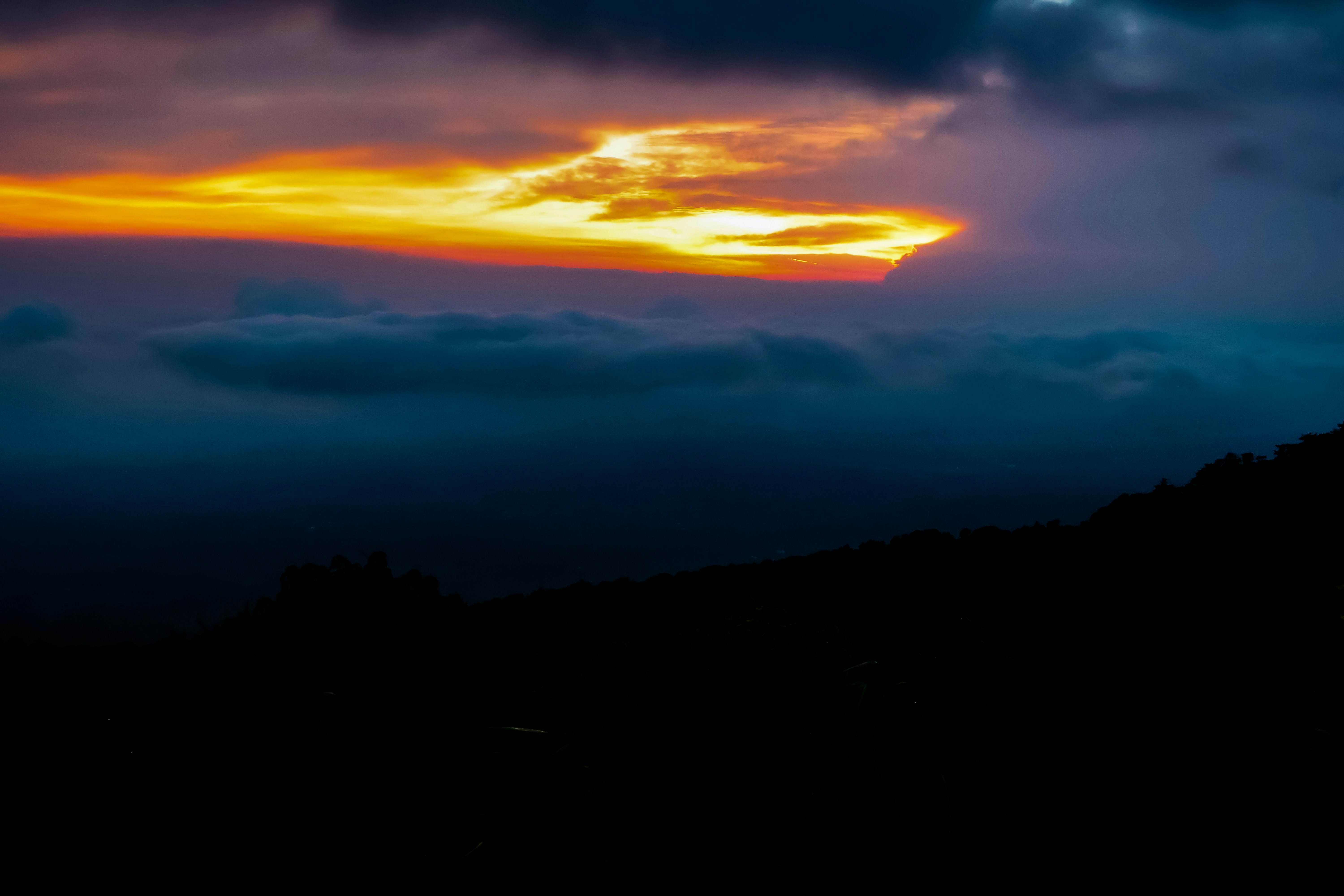 Dramatic sunset illuminates the dark clouds.