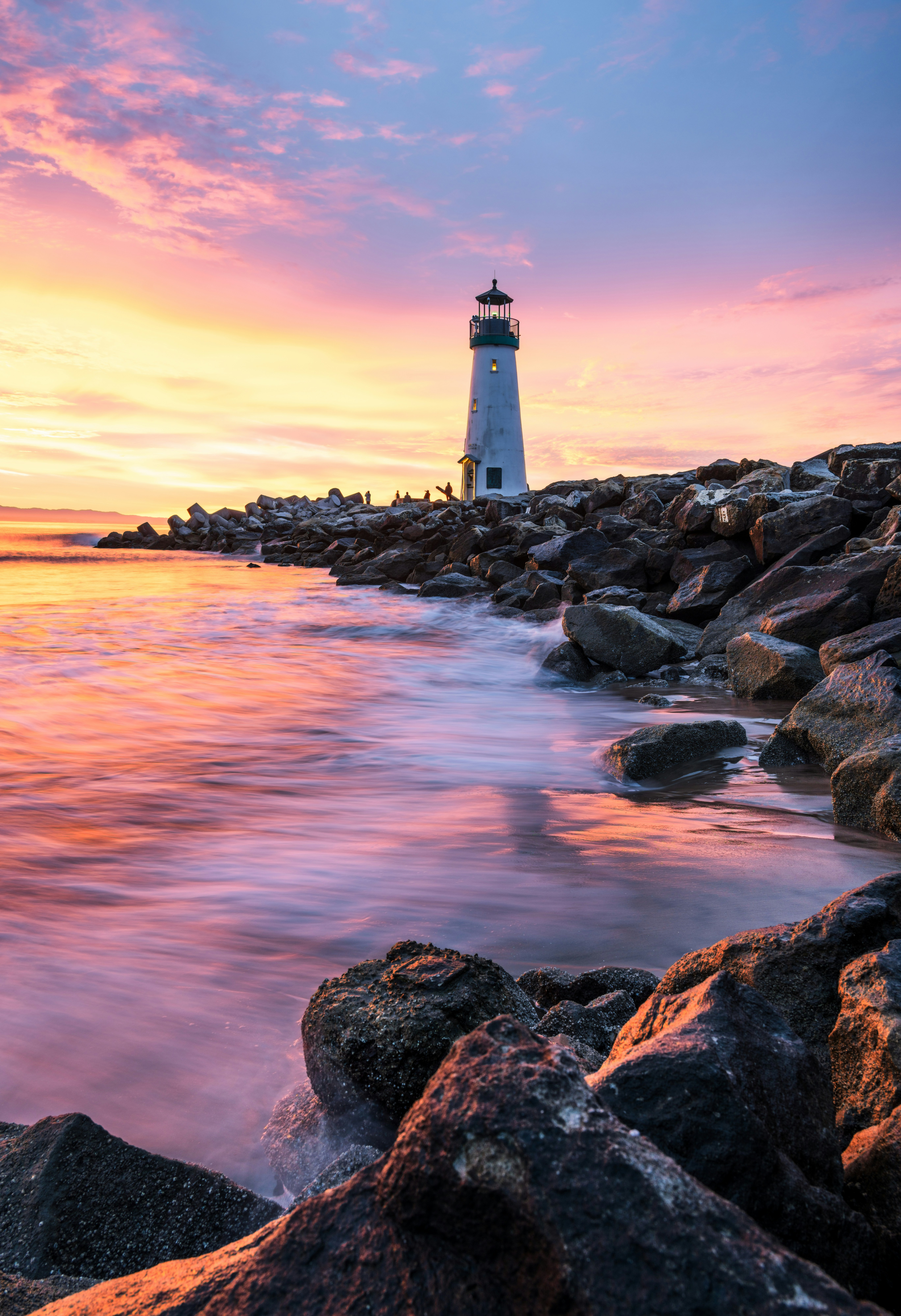 Lighthouse stands tall at a stunning sunset.