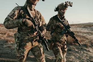 Soldiers walk through a desert landscape.