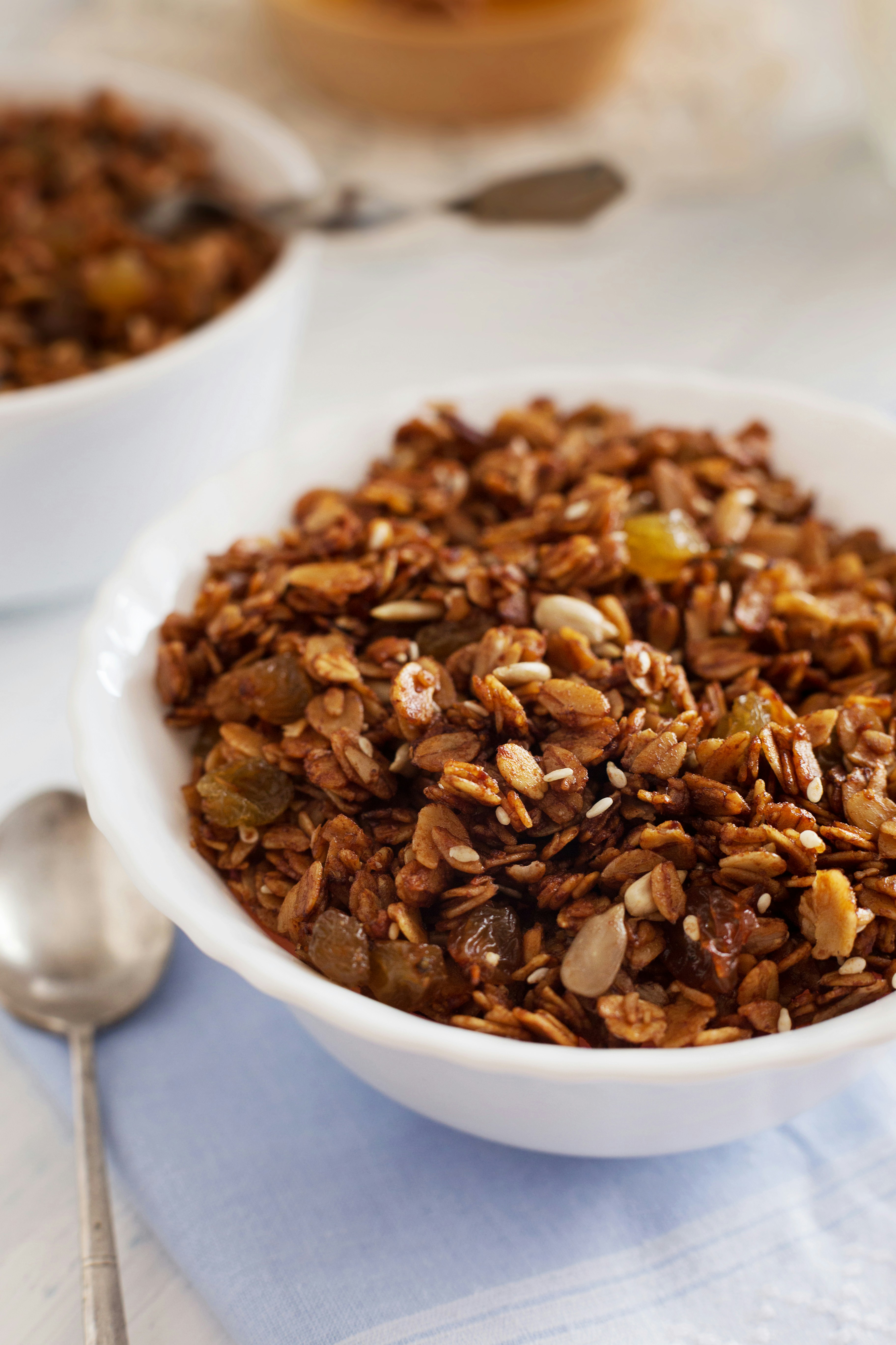 Fresh, delicious granola is served in a white bowl.