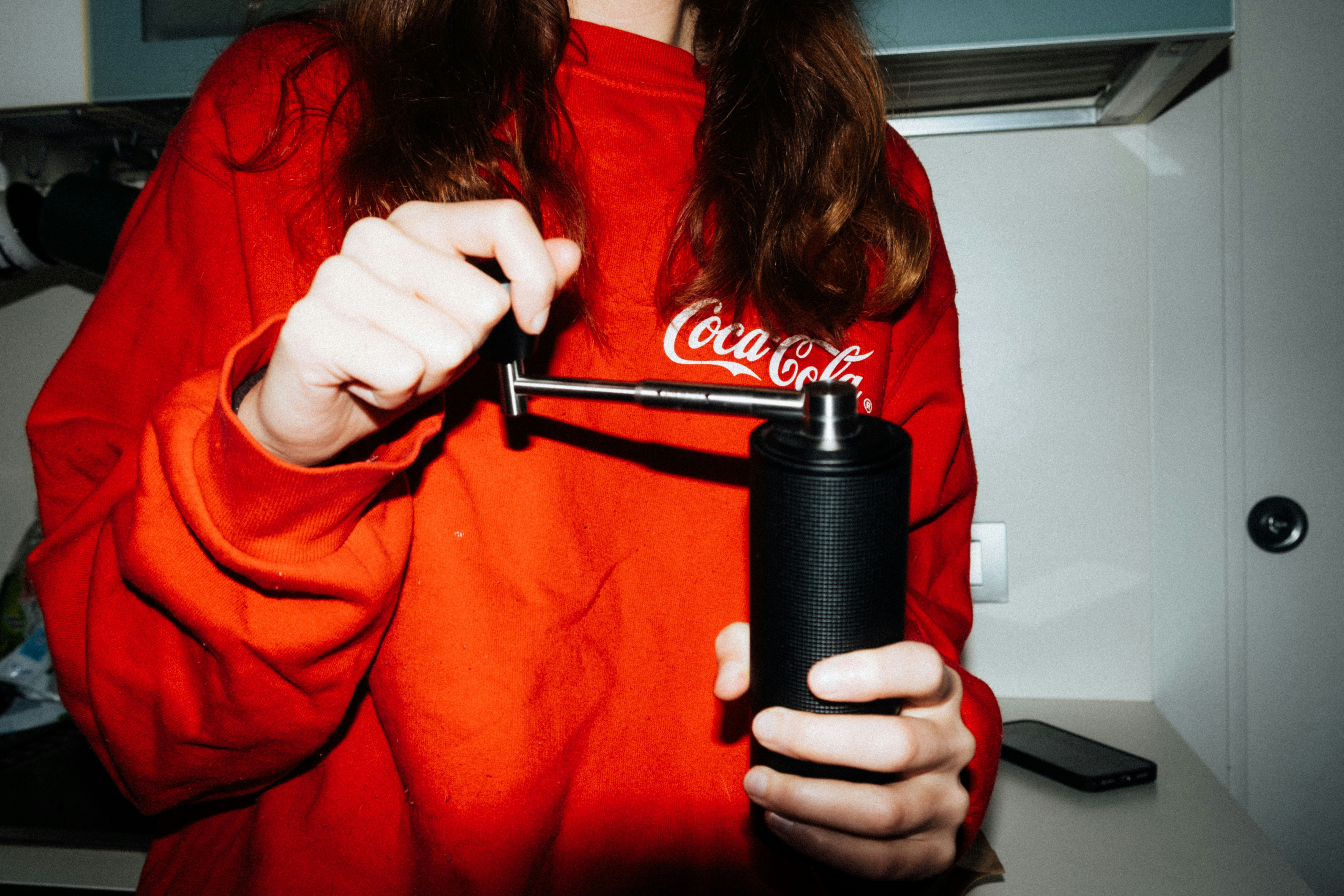 Eine Person hält eine Kaffeemühle in der Hand.